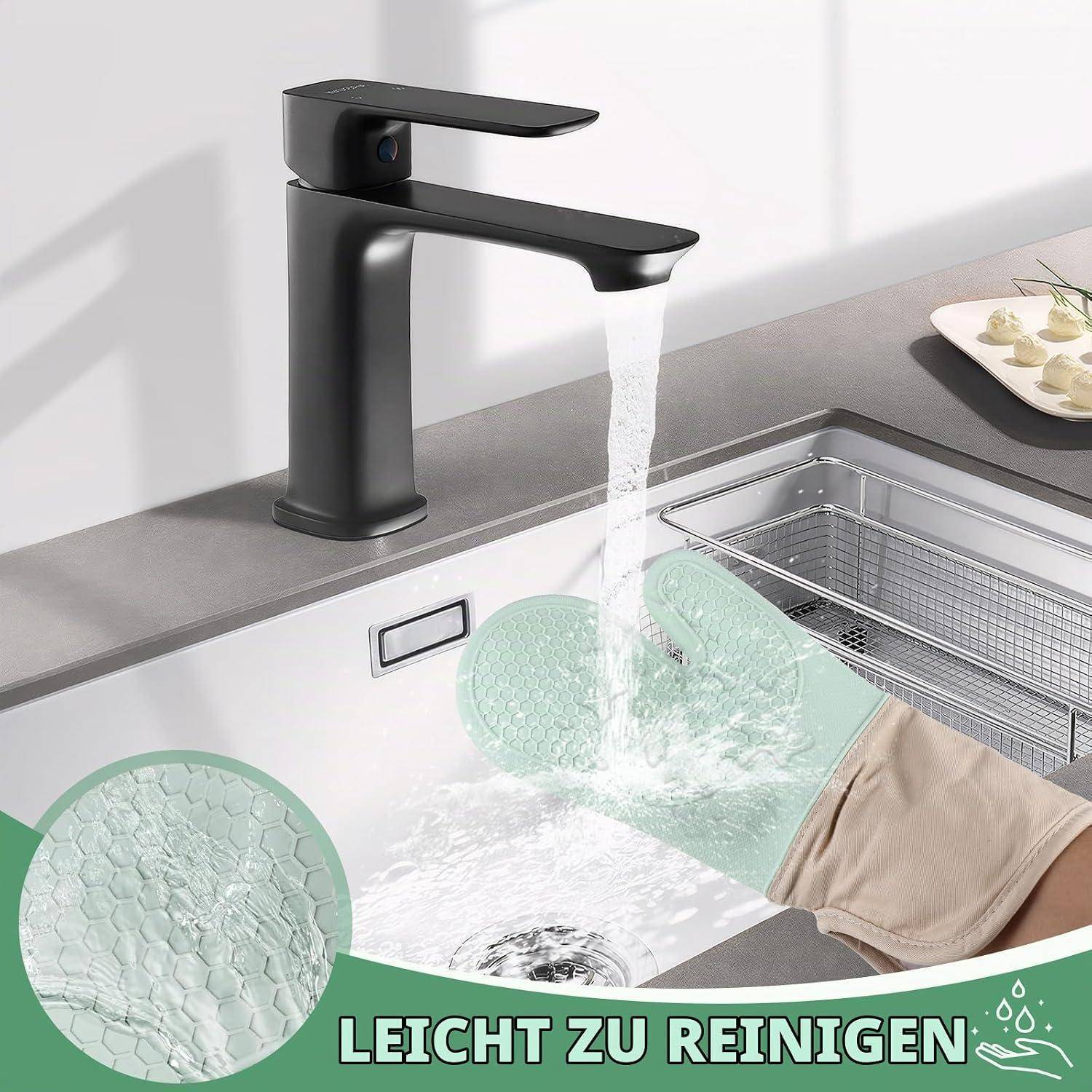 Schwarzer Küchenhahn, aus dem Wasser in ein Spülbecken läuft, während eine behandschuhte Hand ein Glas ausspült; deutscher Text lautet „LEICHT ZU REINIGEN