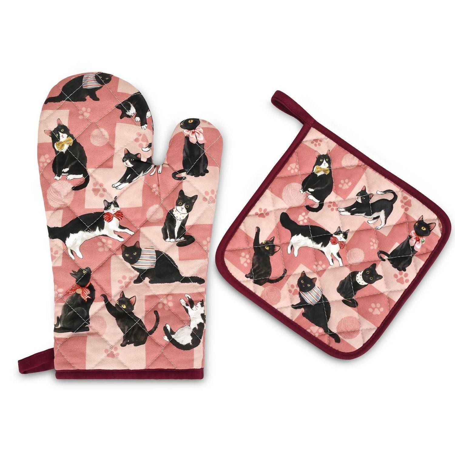 Rosa gesteppter Ofenhandschuh und passende Topflappen mit schwarzem Katzendruck und bordeauxfarbener Borte, auf weißem Hintergrund gezeigt.