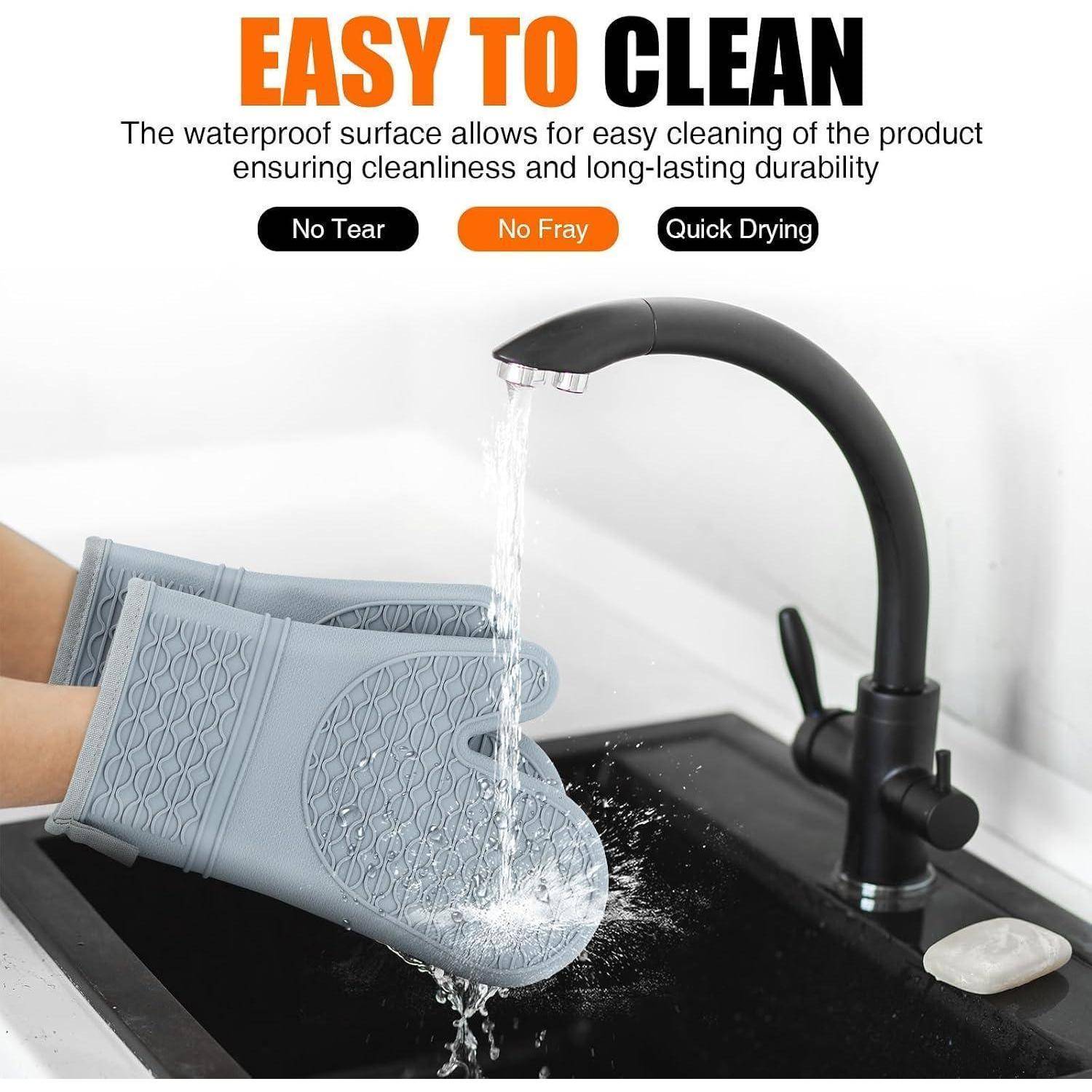 Anzeige, die einen grauen Ofenhandschuh unter fließendem Wasser in einem Waschbecken zeigt, wobei eine leicht zu reinigende, wasserdichte Oberfläche ohne Risse, ohne Ausfransen und mit schneller Trocknung hervorgehoben wird.