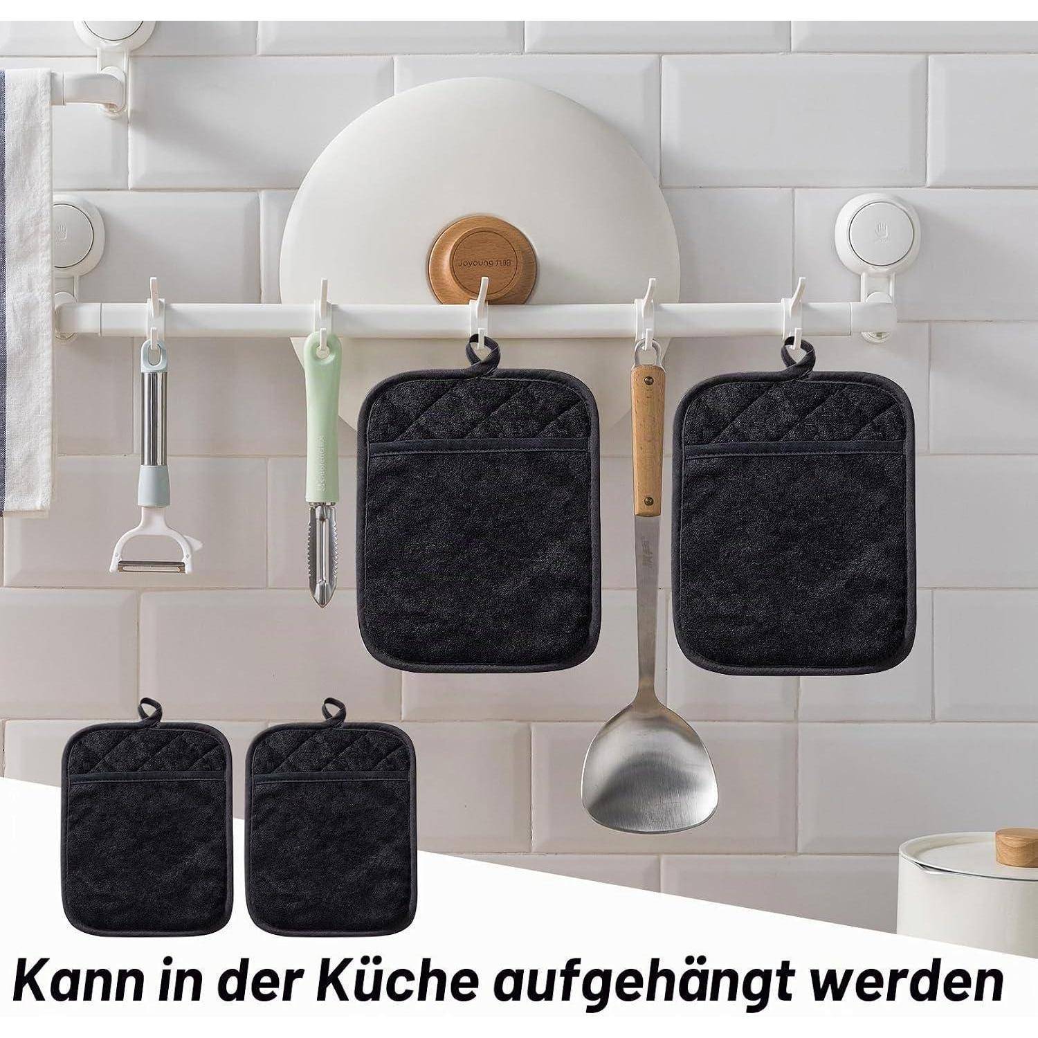Küchenorganizer hängend an einem weißen Wandregal mit Haken, haltend Küchenutensilien und vier schwarze hitzebeständige Taschen.