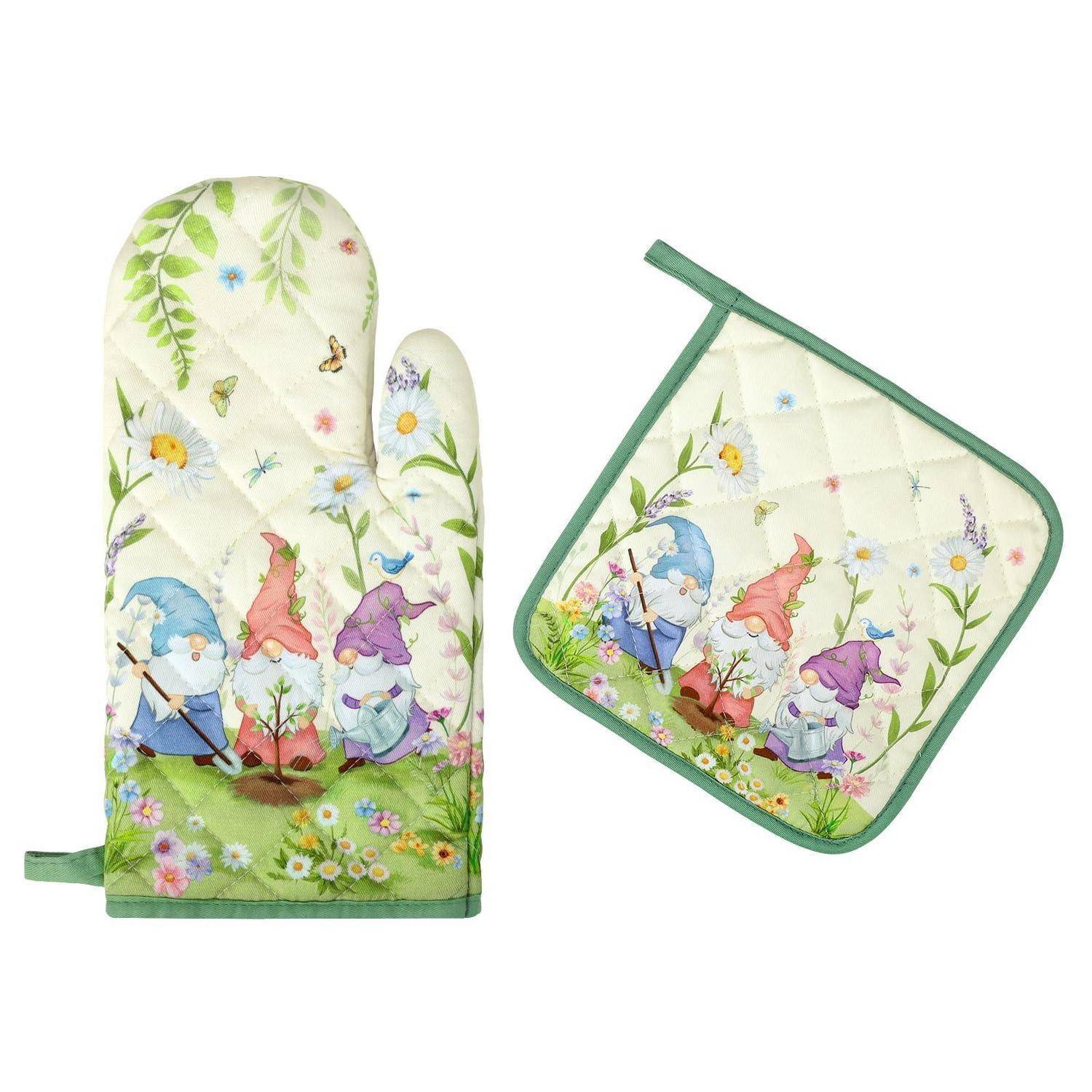 Gesteppter Ofenhandschuh mit Blumenmuster und passender Topflappen mit Gnom- und Schmetterlingsmotiv auf weißem Stoff mit grünem Besatz.