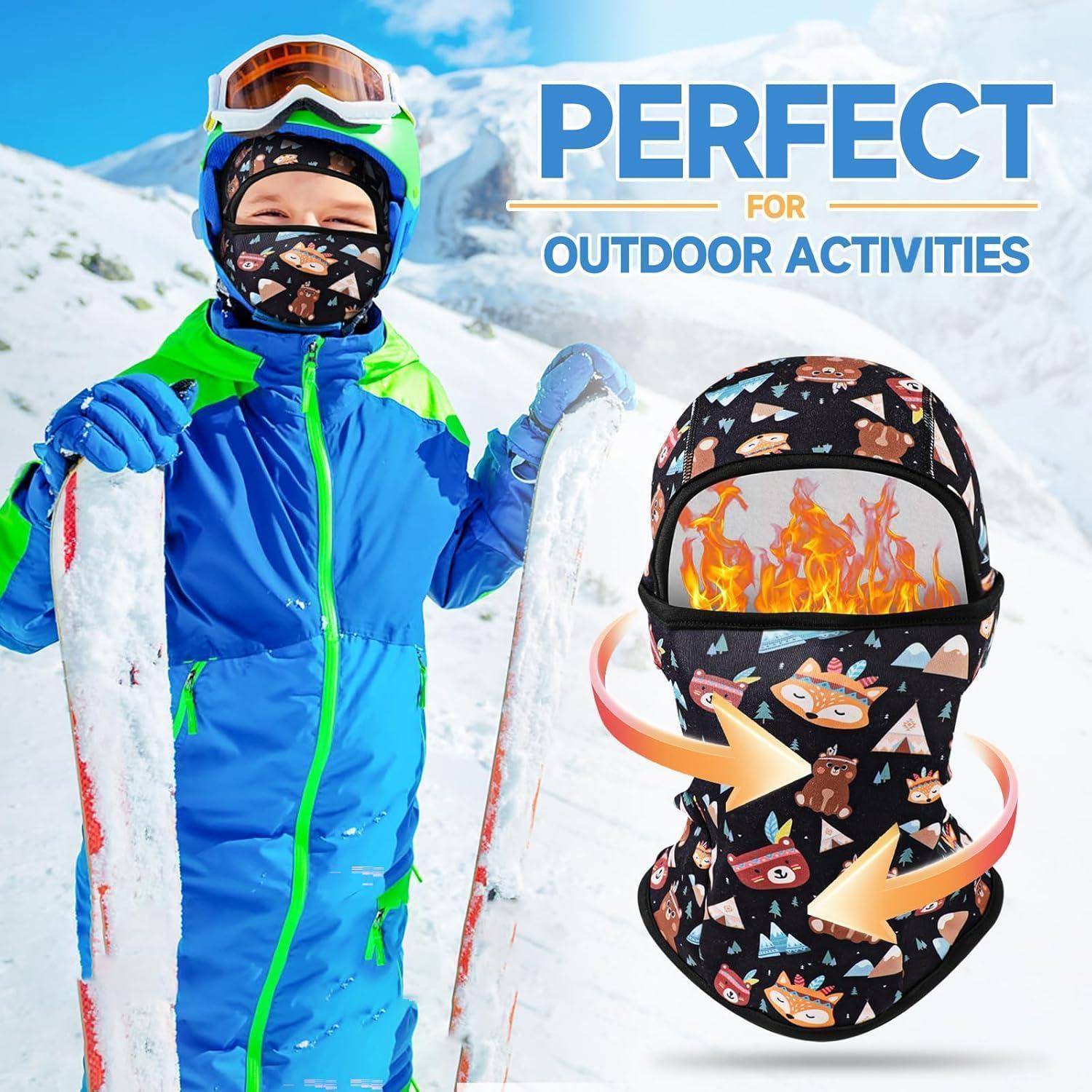 Kind in blauer Skiausrüstung auf einem verschneiten Berg hält Skier, neben einer gemusterten Gesichtsmaske-Grafik mit Flammen; Text lautet „PERFEKT FÜR OUTDOOR-AKTIVITÄTEN".