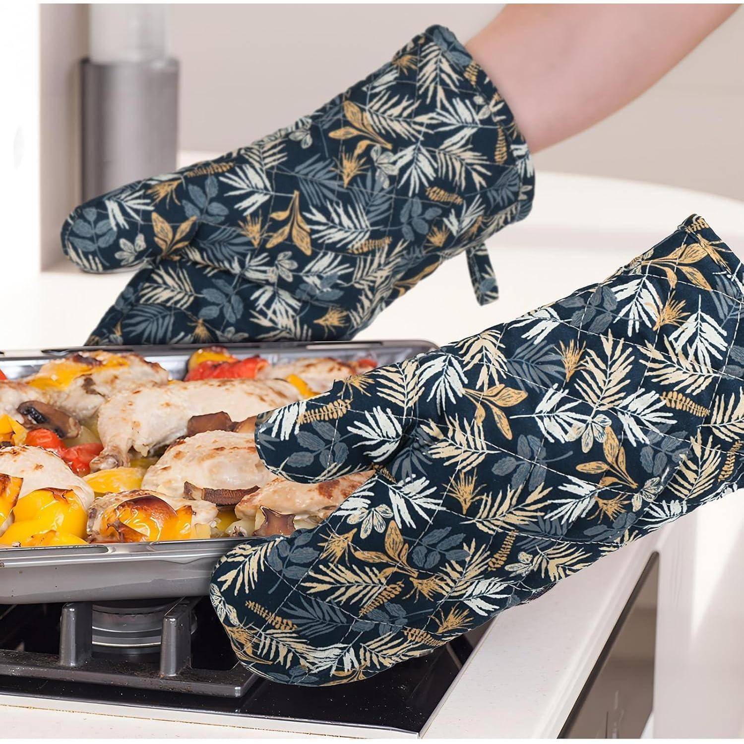 Person mit gemusterten Ofenhandschuhen entnimmt ein heißes Backblech mit Pizza oder Auflauf aus einem Herdoben.