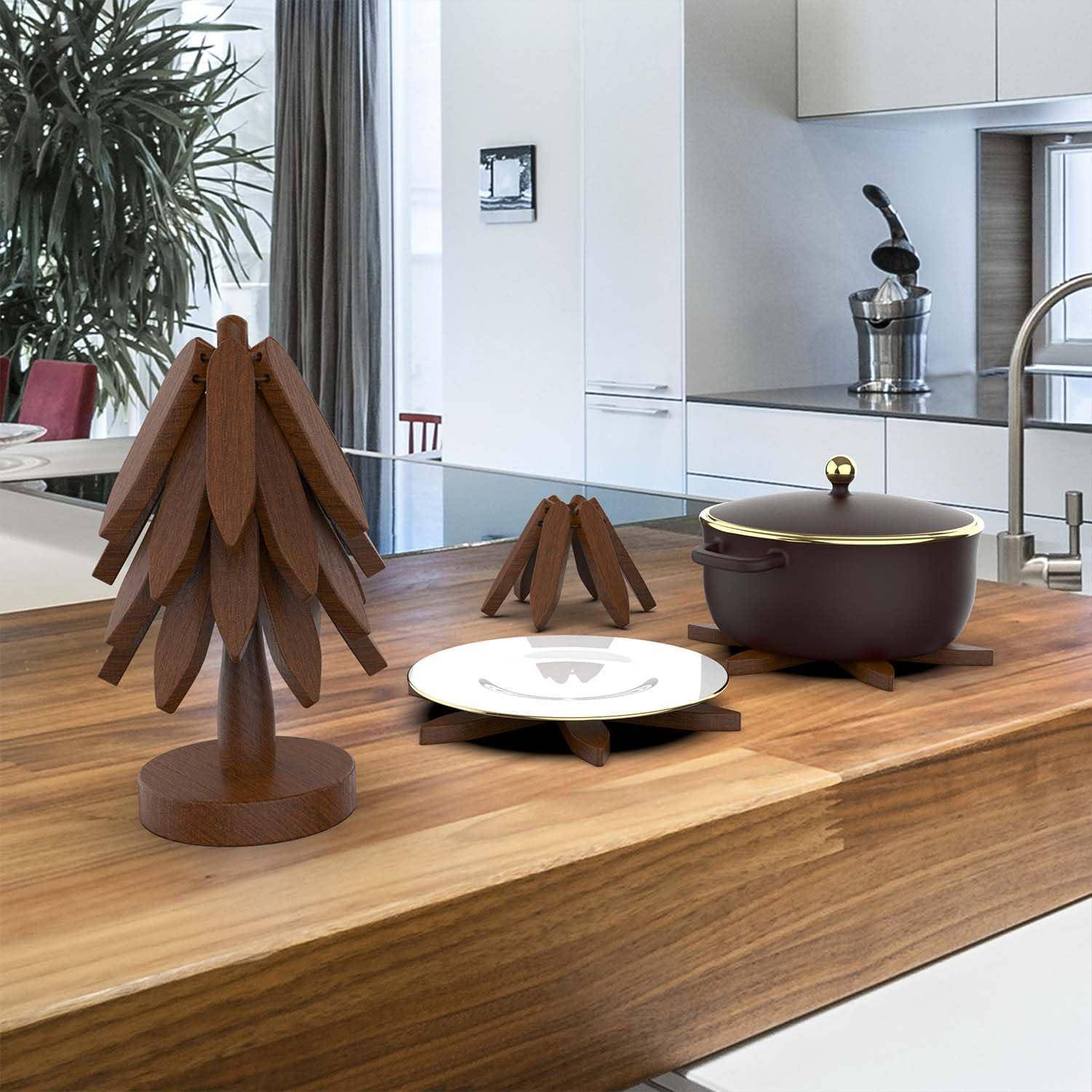 Holztischplatte-Display mit einem stilisierten Baum, einem Teller und einem Topf mit Deckel auf einer Kücheninsel, die dekorative Serviergegenstände zeigt.