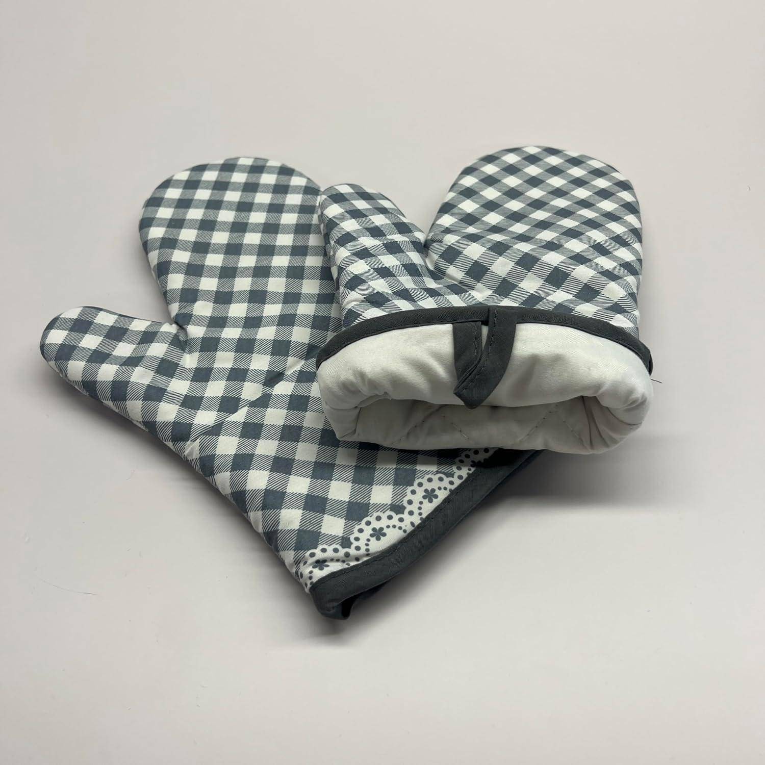 Paar blau-weiß karierter Ofenhandschuhe auf hellem Hintergrund, wobei ein Handschuh auf dem anderen ruht.