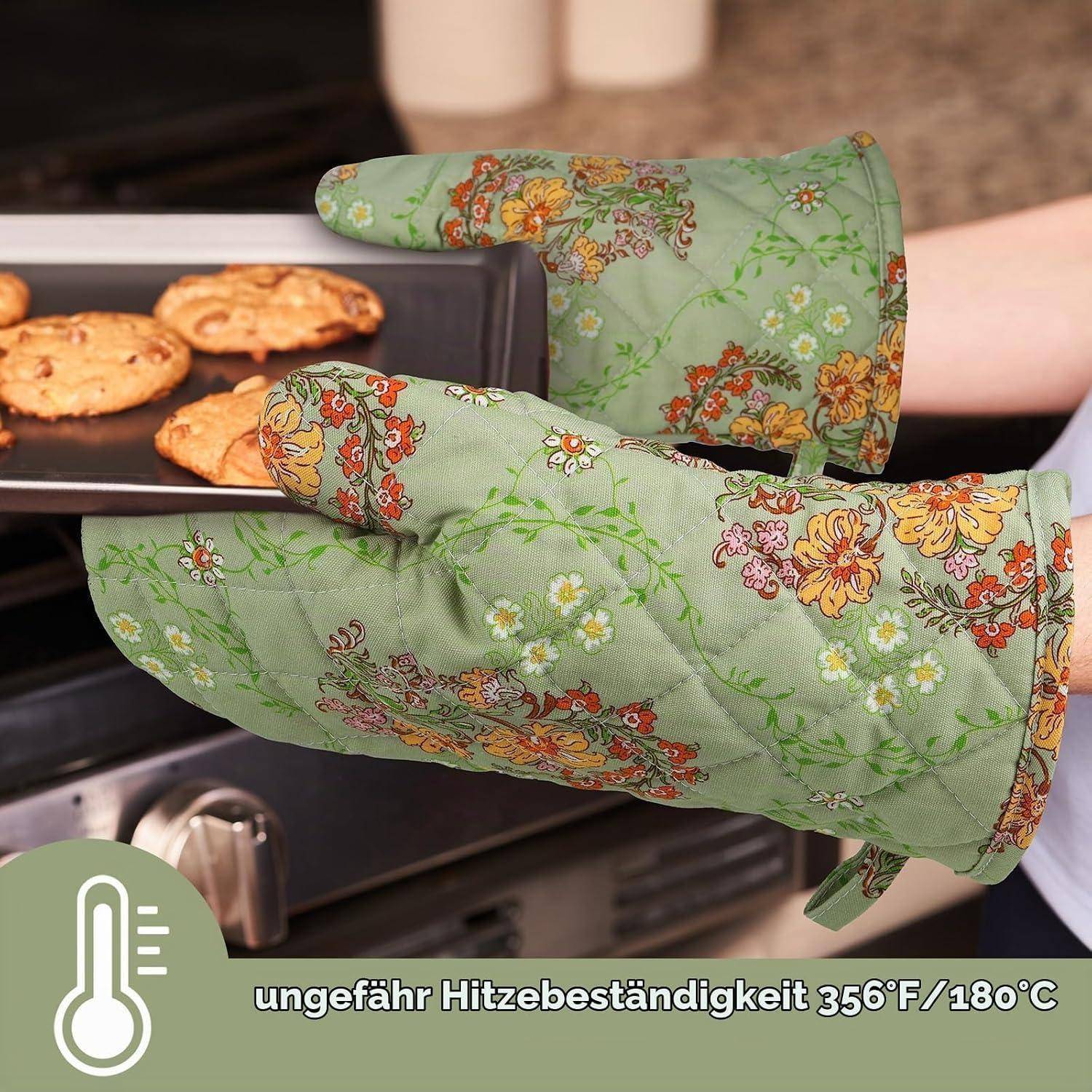 Eine Person mit floralen Ofenhandschuhen nimmt ein Backblech mit Keksen aus dem Ofen und zeigt dabei eine Wärmebeständigkeit von 356°F/180°C.
