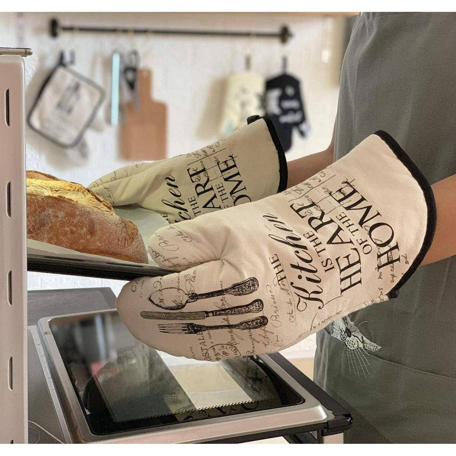 Eine Person mit Ofenhandschuhen nimmt einen Laib Brot aus einem Ofen oder Toasterofen in einer Küche heraus.