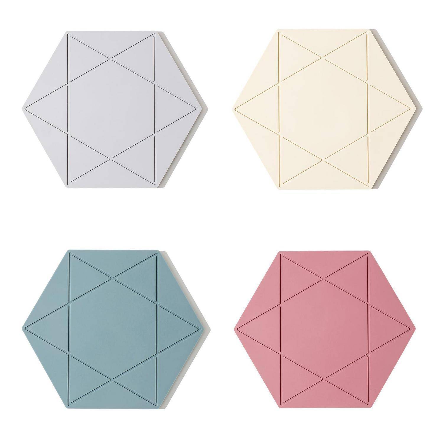 Vier sechseckige gefaltete Papierkuverts in Grau, Creme, Blau und Rosa, jeweils mit geometrischen Nahtlinien auf weißem Hintergrund.