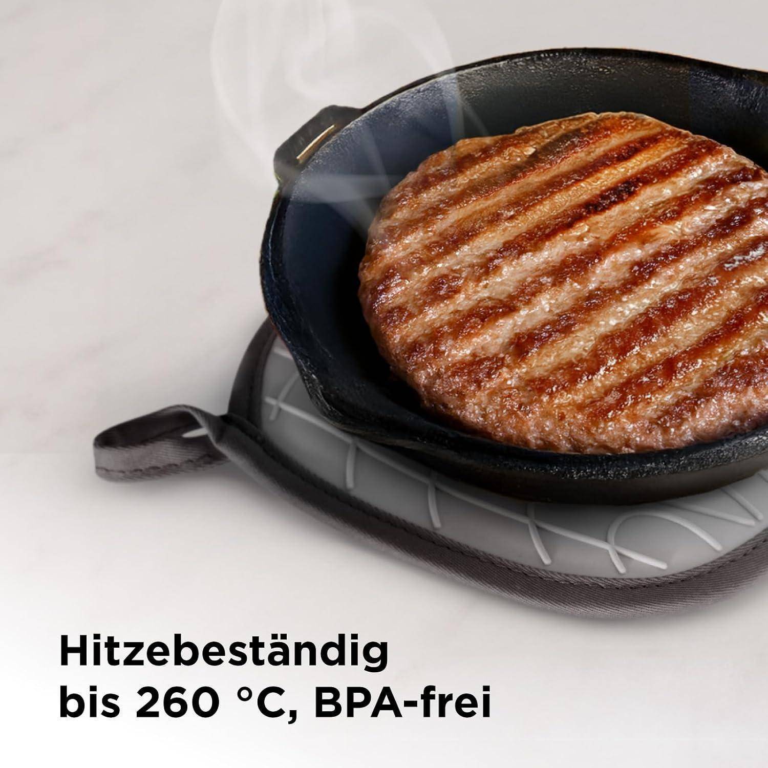 Grillpfanne mit einem Burger-Patty auf einer hitzebeständigen Unterlage; deutscher Text besagt 