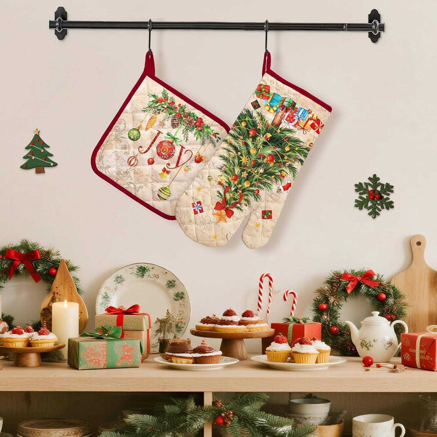 Festliche Küchendarstellung mit zwei Weihnachtsküchenhandschuhen, die über einem Tisch mit Weihnachtsleckereien, Geschenken, Kränzen, Kerzen und dekorativen Tellern hängen.