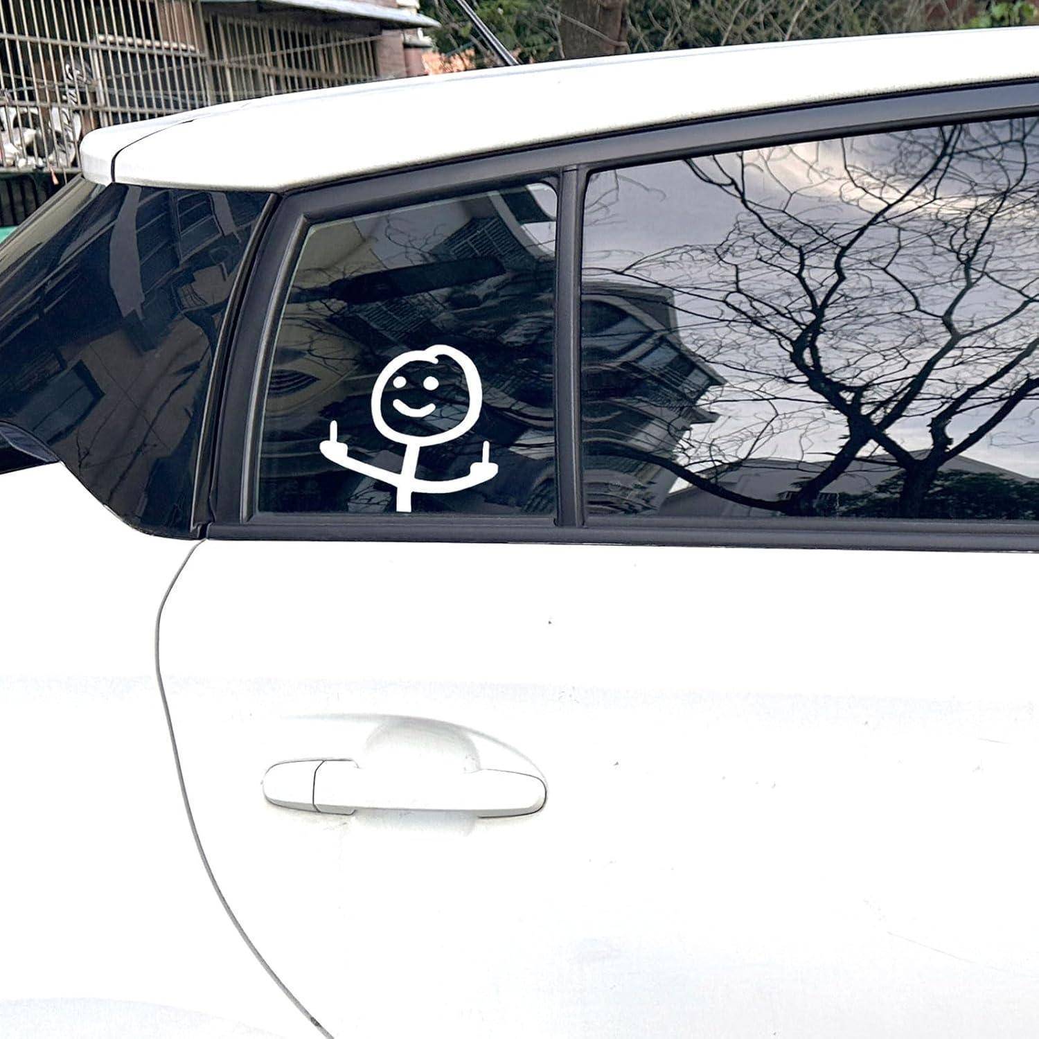 Weiße Autofenster auf der Rückseite mit einer lächelnden Strichmännchen-Aufklebung auf der Heckscheibe; Spiegelungen von kahlen Bäumen sind im Glas sichtbar.