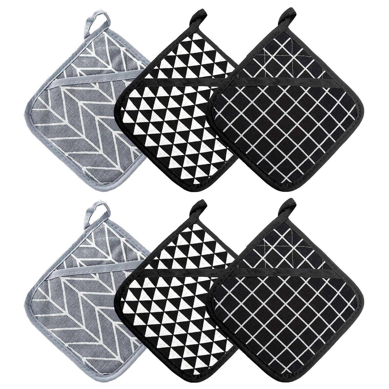 Sechs gesteppte quadratische Topflappen in Grau und Schwarz mit geometrischen Mustern, in zwei Reihen vor weißem Hintergrund angezeigt.
