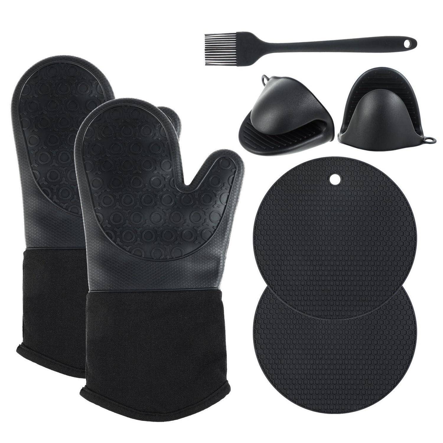 Schwarzes Backset mit zwei Ofenhandschuhen, einem Gebäckpinsel, zwei Prise-Schüsseln und zwei runden antihaftbeschichteten Backmatten auf weißem Hintergrund