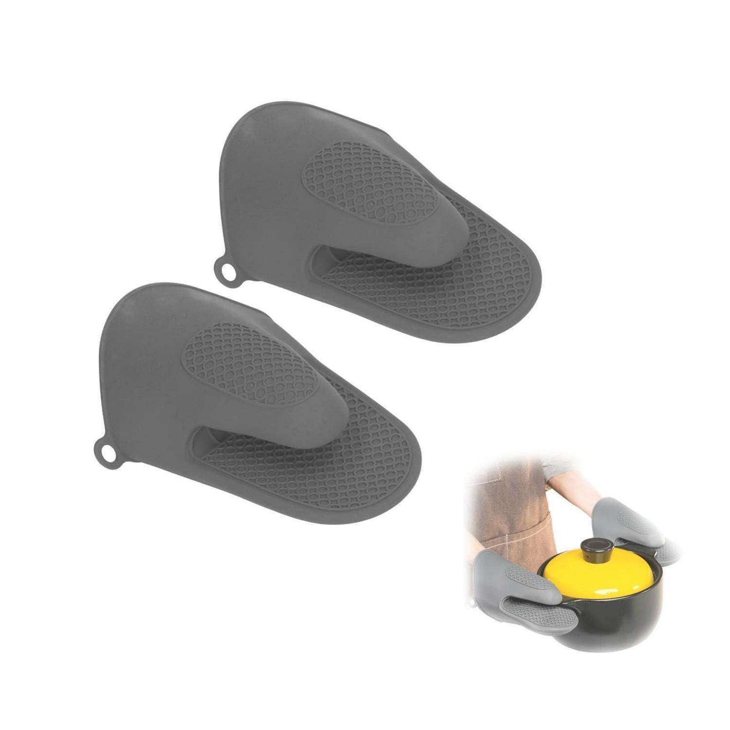 Graue Silikon-Topflappen, dargestellt als Paar, mit einer kleinen Einfügung einer Hand, die einen verwendet, um einen heißen gelb-schwarzen Topf zu halten.