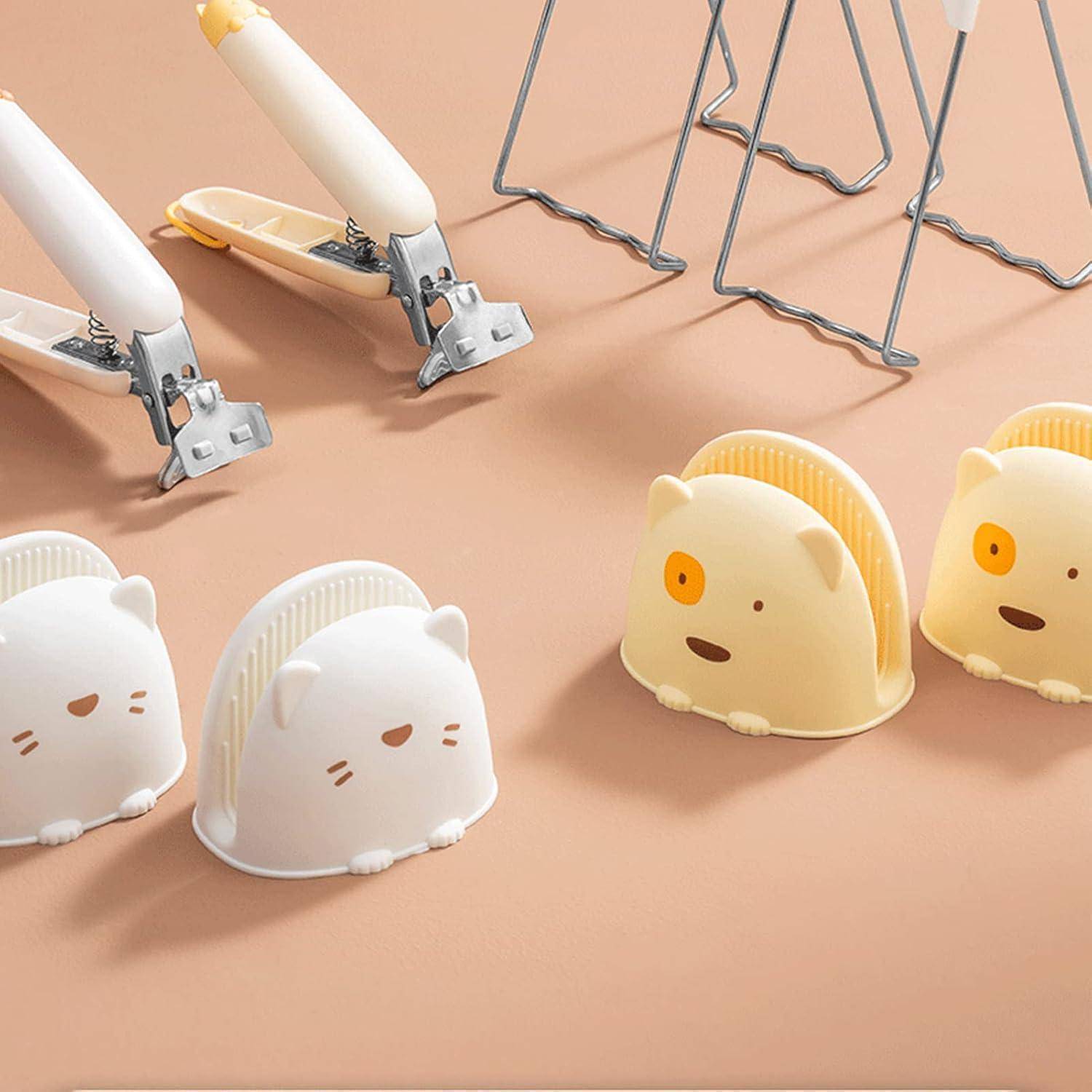 Satz süßer tierförmiger Haarklammern oder Haarspangen in Weiß und Creme, präsentiert auf einem Pfirsichhintergrund mit sichtbaren Metallclip-Mechanismen.
