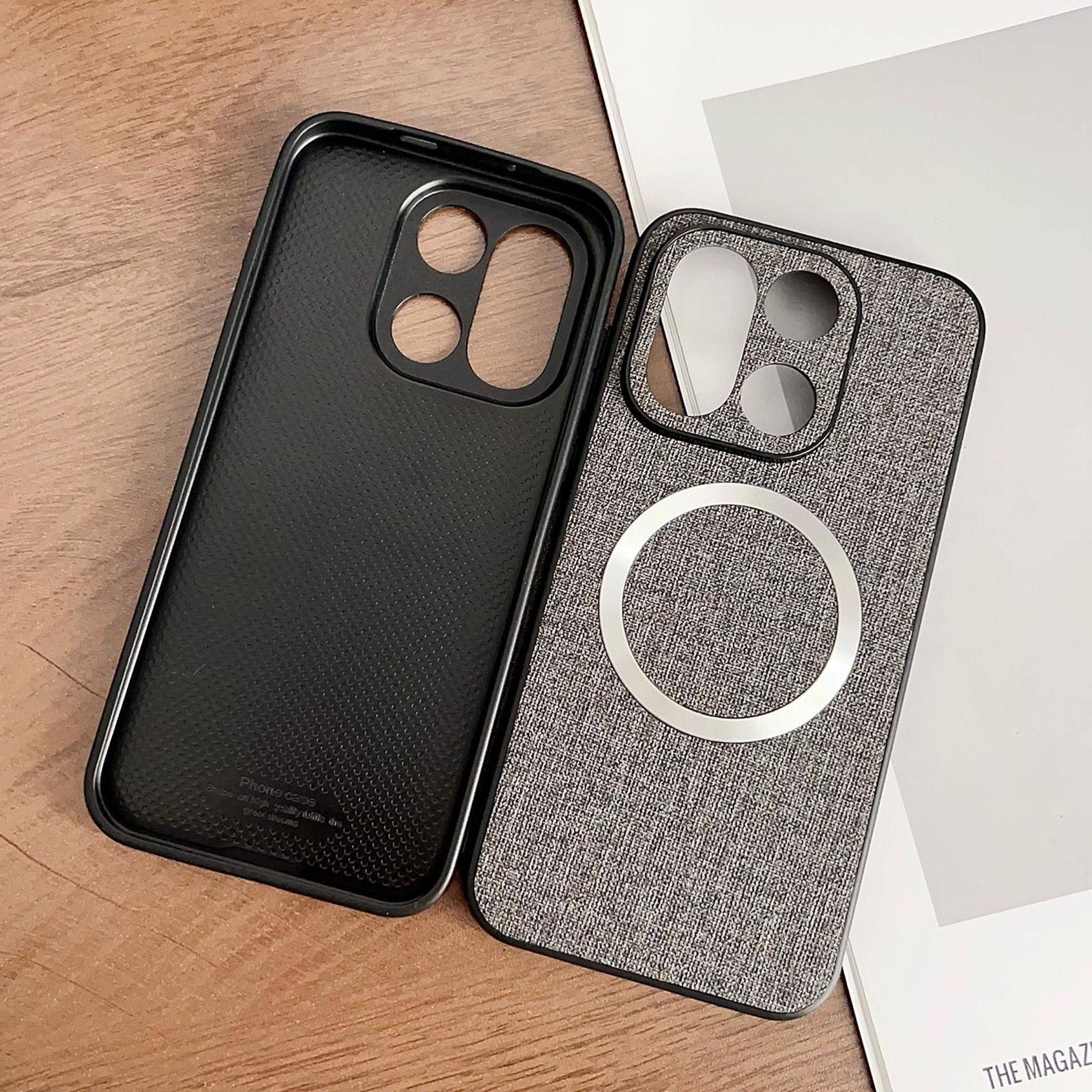 Zwei Handyhüllen auf einem Holztisch: eine schwarze strukturierte Hülle und eine graue Stoff-Optik-MagSafe-Hülle mit einem kreisförmigen Magnetring.