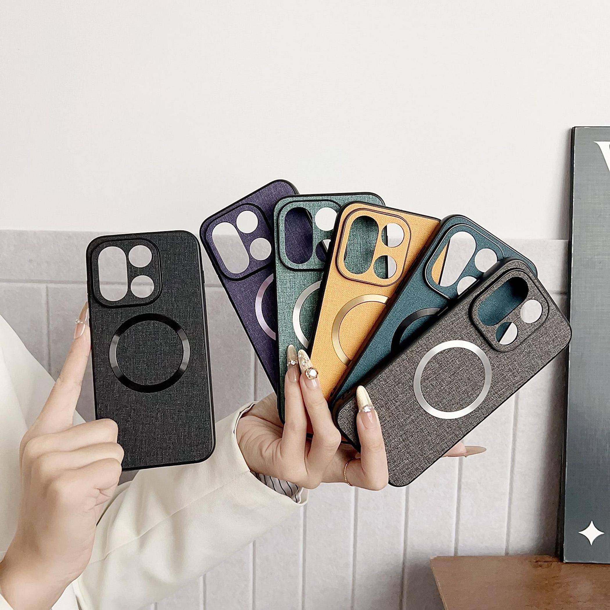 Hände halten sechs Smartphone-Hüllen in verschiedenen Farben und Texturen, fächerartig angeordnet, um unterschiedliche Kameraausschnitte und Magnetring-Designs zu zeigen.