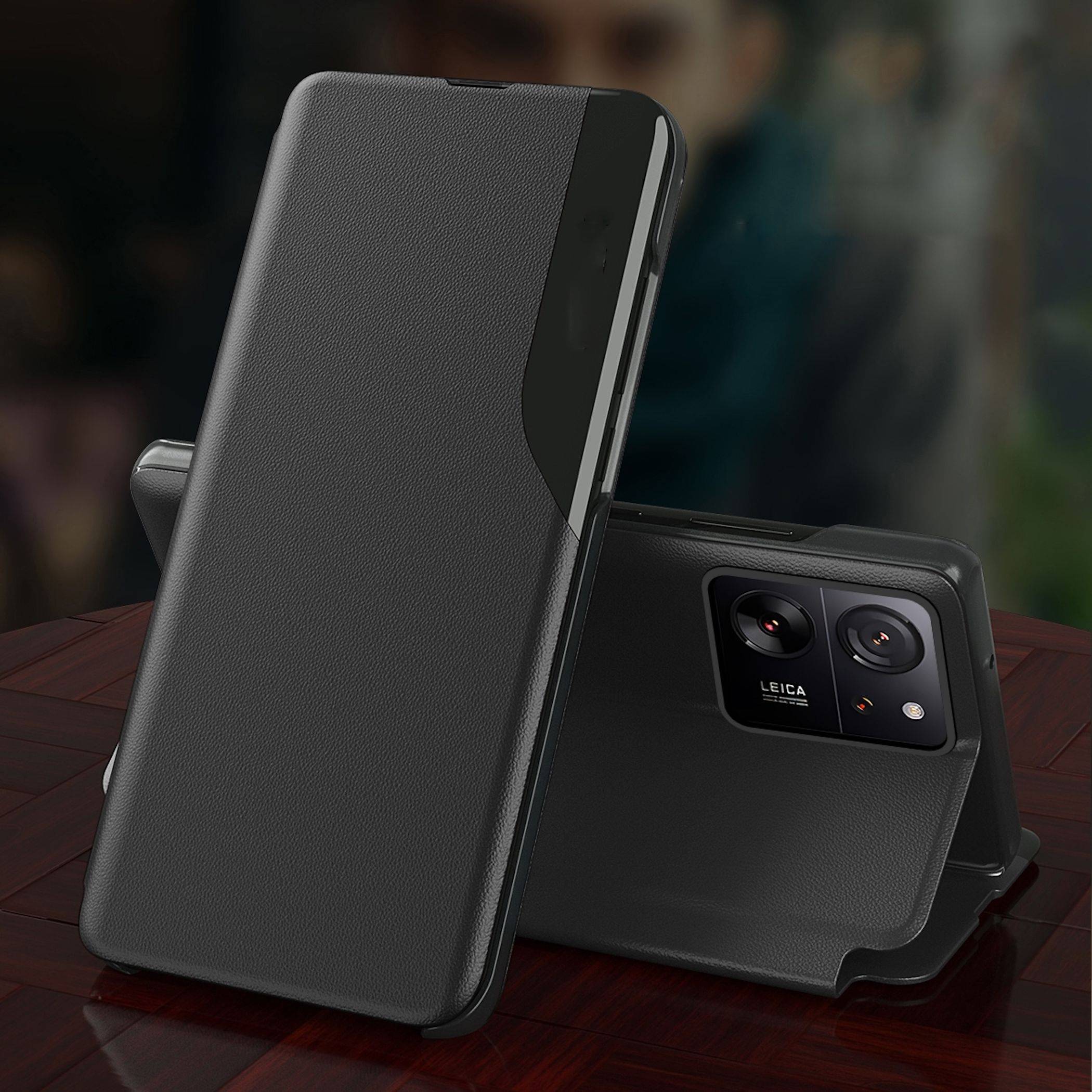 Zwei schwarze Smartphone-Hüllen auf einem Tisch dargestellt, eine aufrecht und eine flach liegend, um die Aussparung der hinteren Kamera zu zeigen.