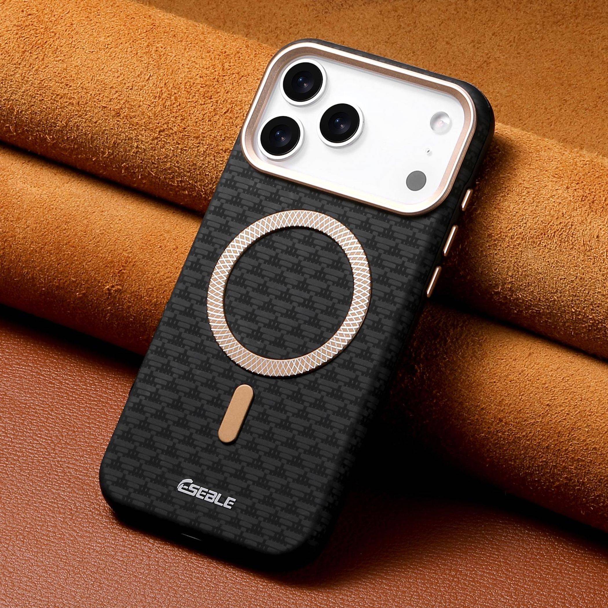 Ein schwarzes gemustertes Smartphone-Etui mit MagSafe-Ring, gezeigt auf einer beigen Lederfläche.
