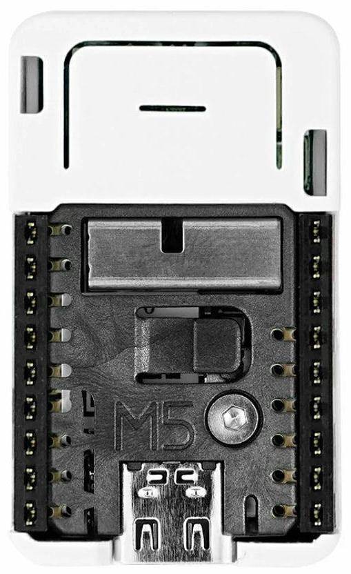Nahaufnahme eines schwarzweißen elektronischen Steckers oder Adapters mit einem USB-Anschluss und einer zentralen Befestigungsschraube auf einem rechteckigen Gerät.