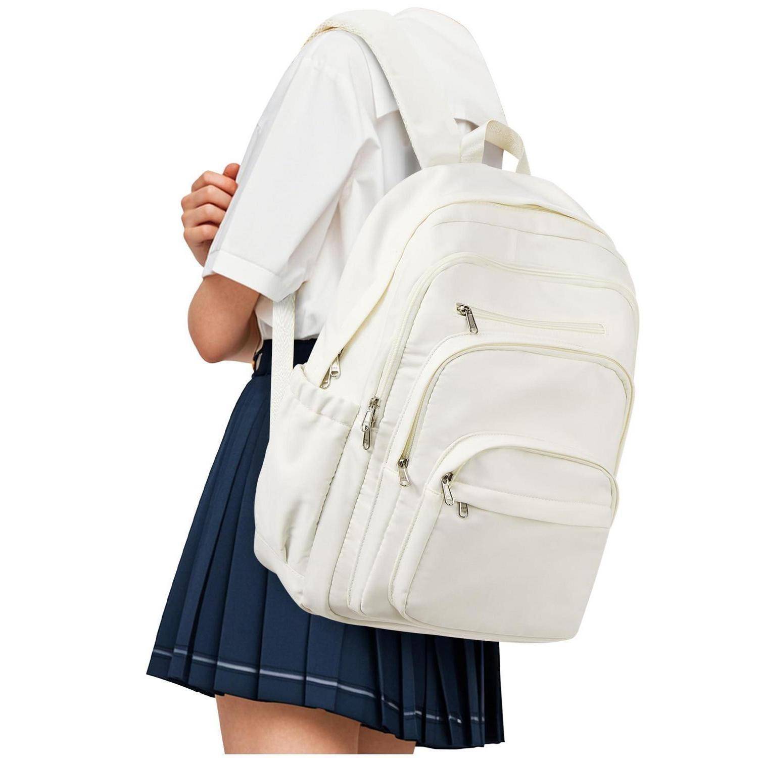 Mädchen in einer Schuluniform, das einen großen weißen Rucksack vor einem einfachen Hintergrund trägt.