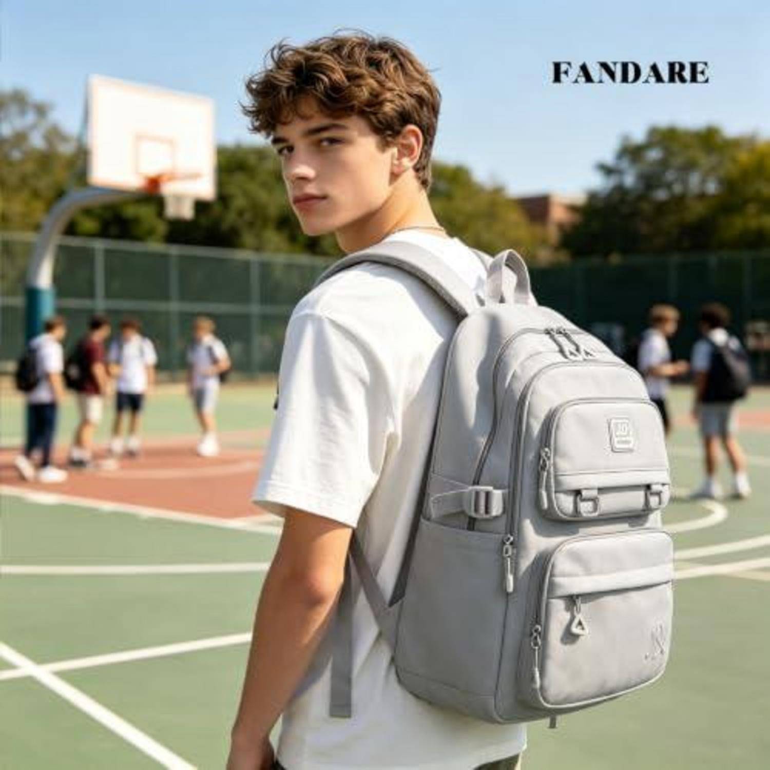 Junger Mann mit einem grauen Rucksack auf einem Outdoor-Basketballplatz, schaut zurück zur Kamera; 'FANDARE' erscheint oben rechts.