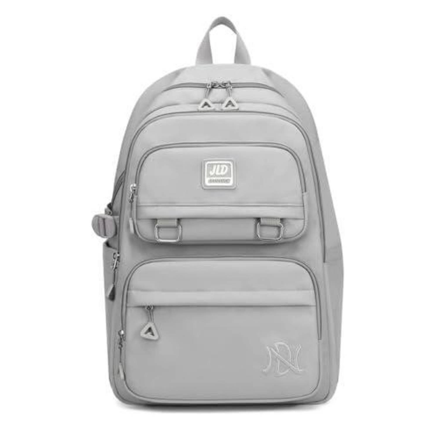 Grauer Rucksack mit mehreren Reißverschlusstaschen an der Vorderseite, Griffschlaufe oben und Logo-Patch, auf weißem Hintergrund abgebildet.