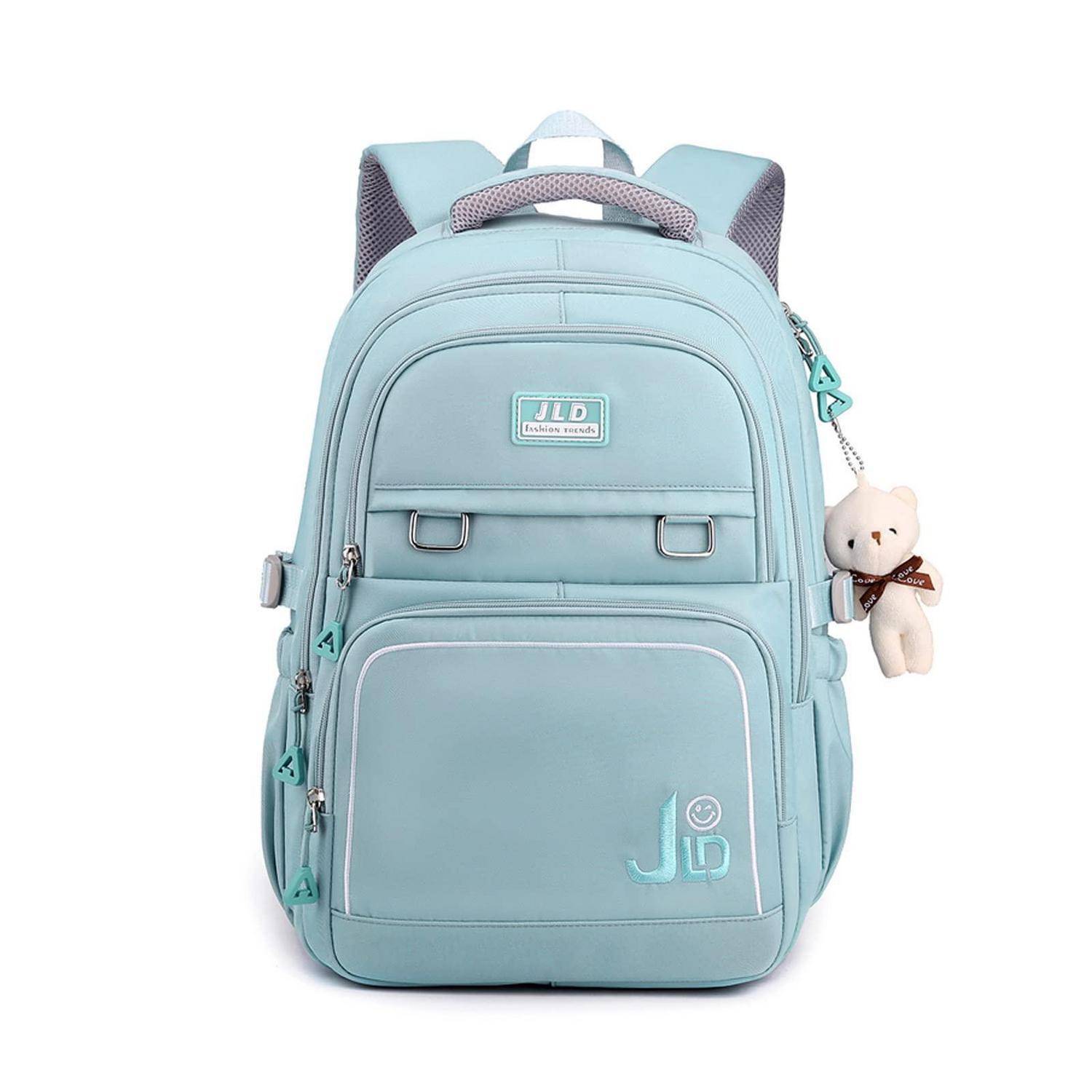 Hellblauer Rucksack mit mehreren Reißverschlussfächern und einem kleinen Teddybär-Anhänger, der an der Seite hängt.