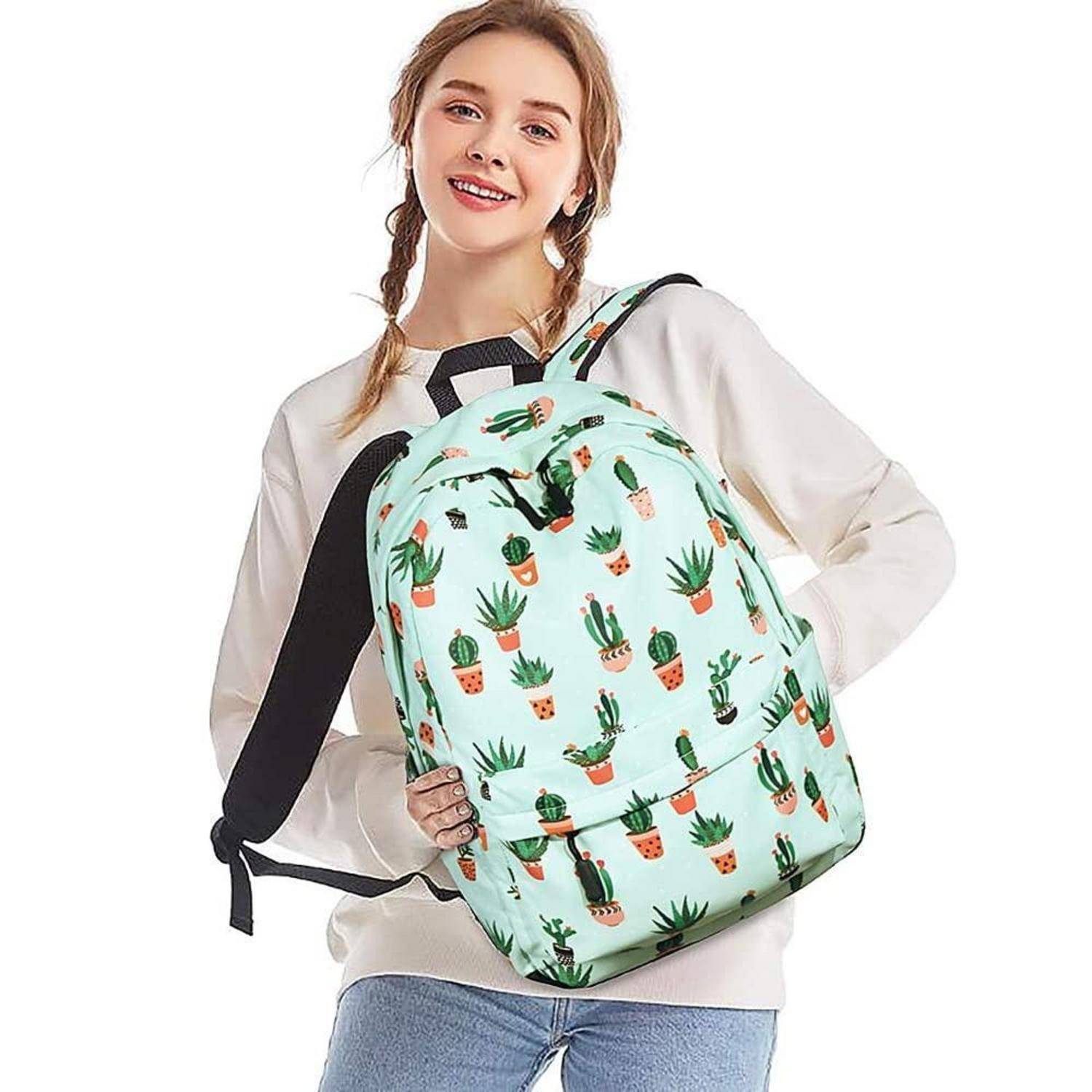 Junge Frau, die einen mintgrünen Rucksack mit Kaktus-Muster modelliert, wobei das vordere Design der Tasche und die schwarzen Schultergurte vor weißem Hintergrund gezeigt werden.