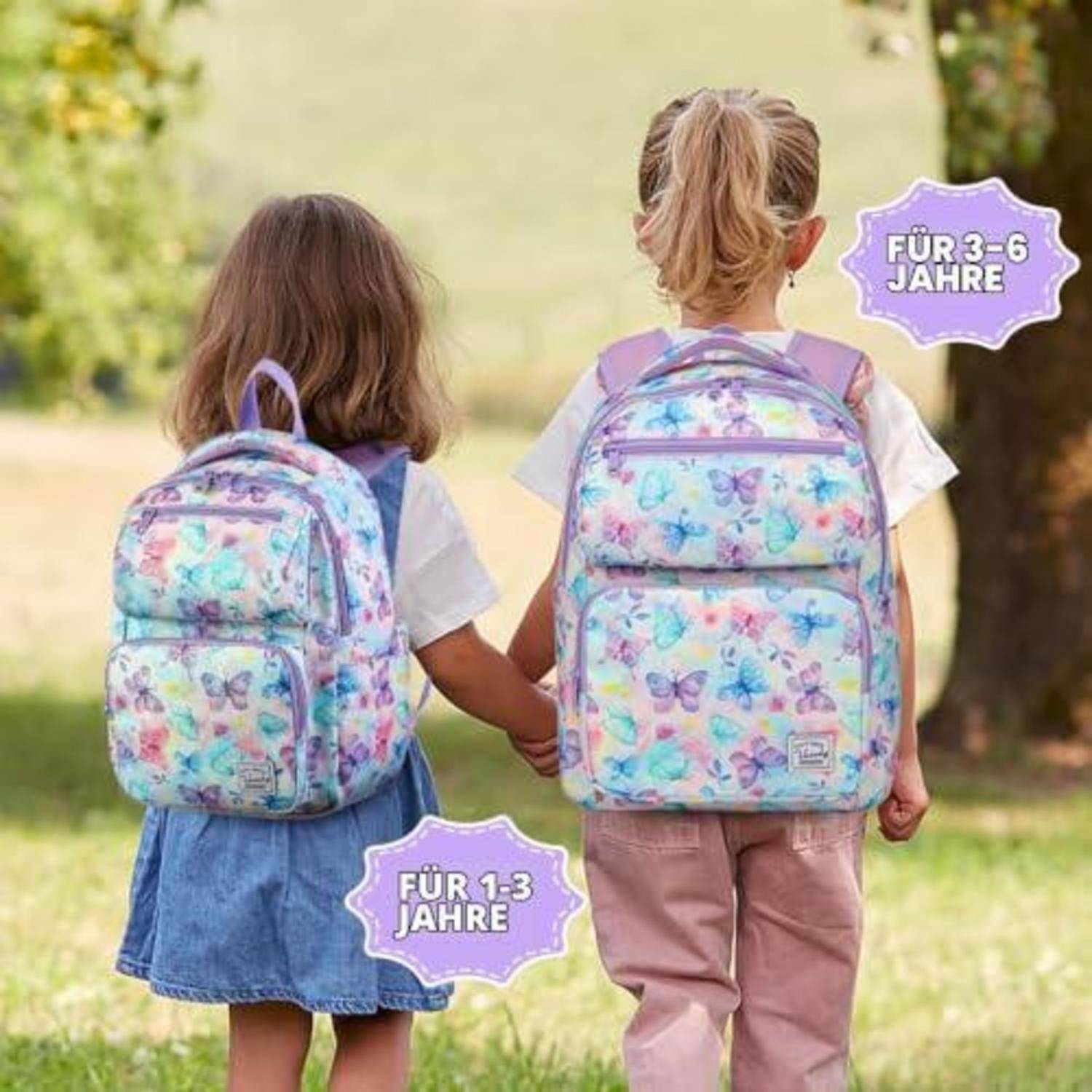 Zwei kleine Kinder halten sich an den Händen und tragen pastellfarbene Schmetterlingsrucksäcke, gekennzeichnet für die Altersgruppen „FÜR 1-3 JAHRE