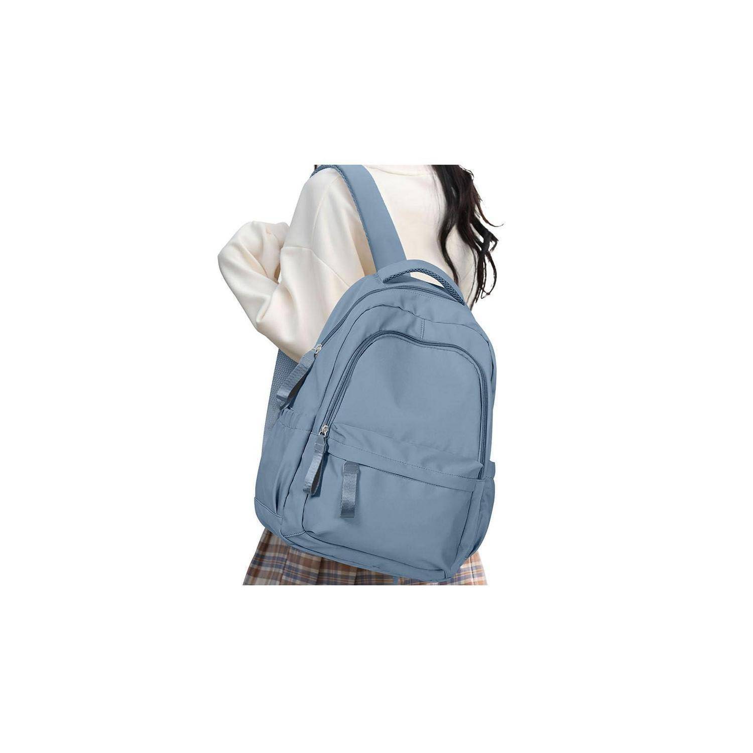 Hellblauer Rucksack, der über der Schulter einer Person gegen einen einfachen weißen Hintergrund getragen wird.