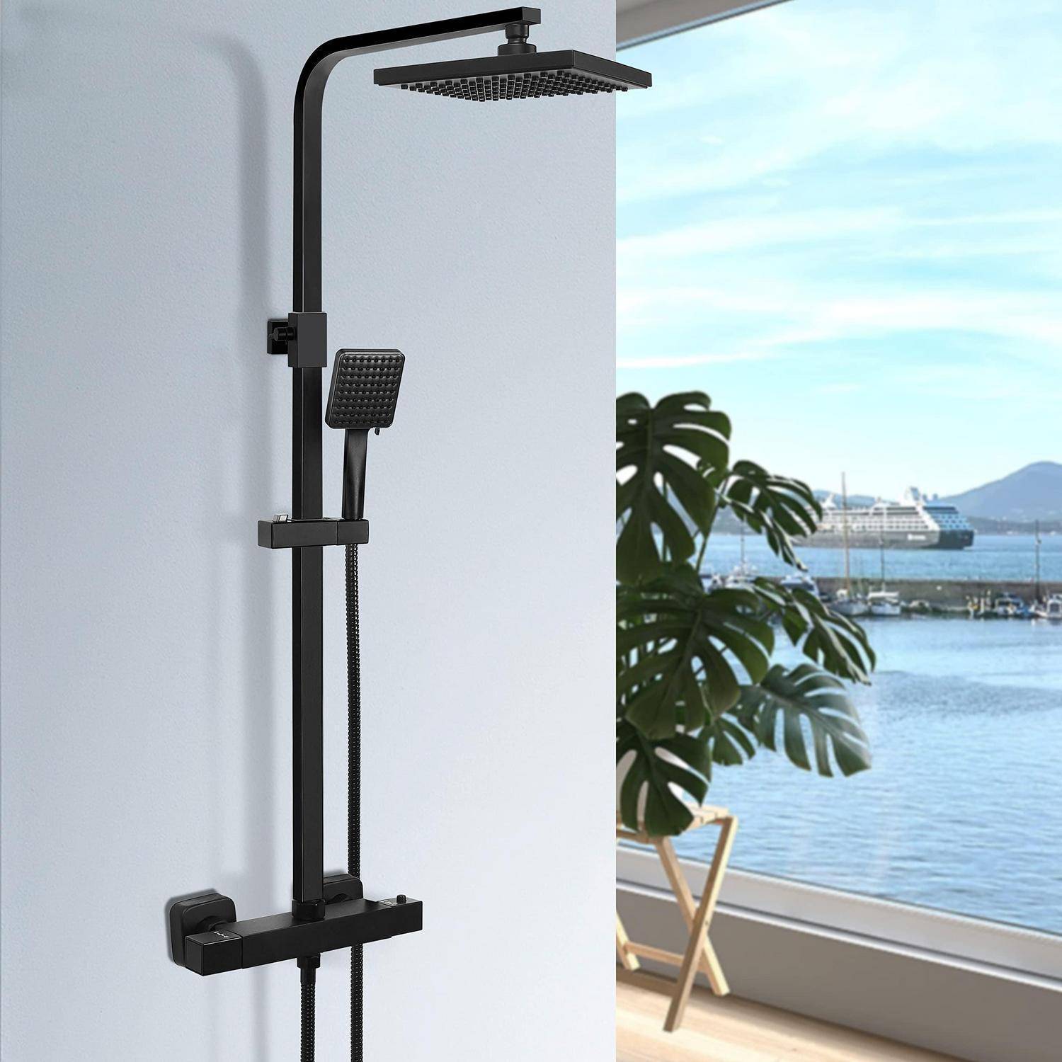 Schwarze, wandmontierte Regendusche mit tragbarem Handbrausekopf in einem modernen Badezimmer neben einem Fenster mit Blick auf das Wasser.