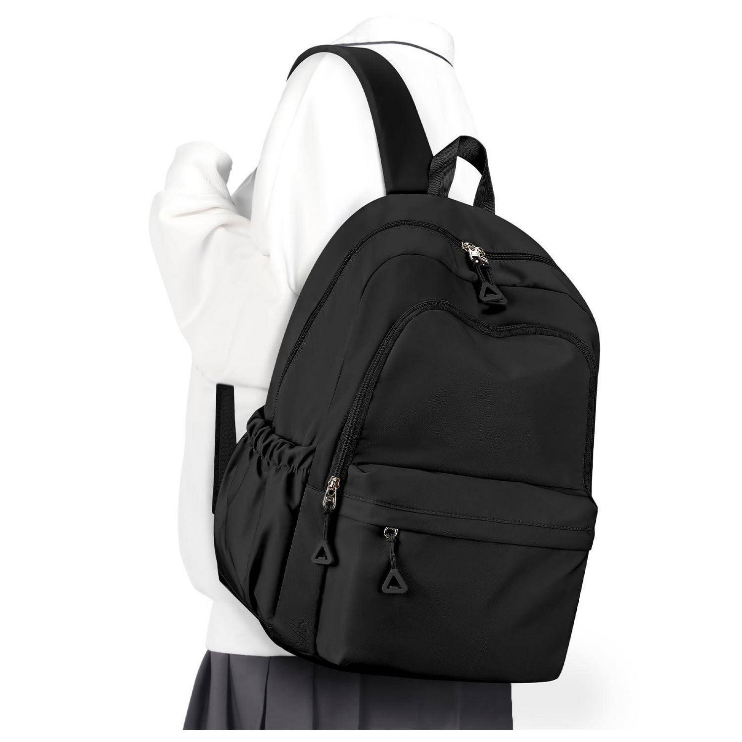 Schwarzer Rucksack, über der Schulter getragen von einer Person in einem weißen Kapuzenpullover, vor einem einfarbigen Hintergrund gezeigt.