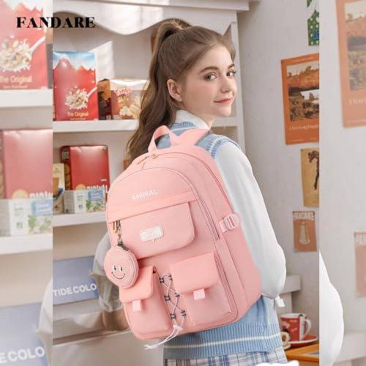 Junge Frau mit einem rosa Rucksack und einem Smiley-Anhänger, posierend in einem Pastellzimmer mit Regalen und Postern.