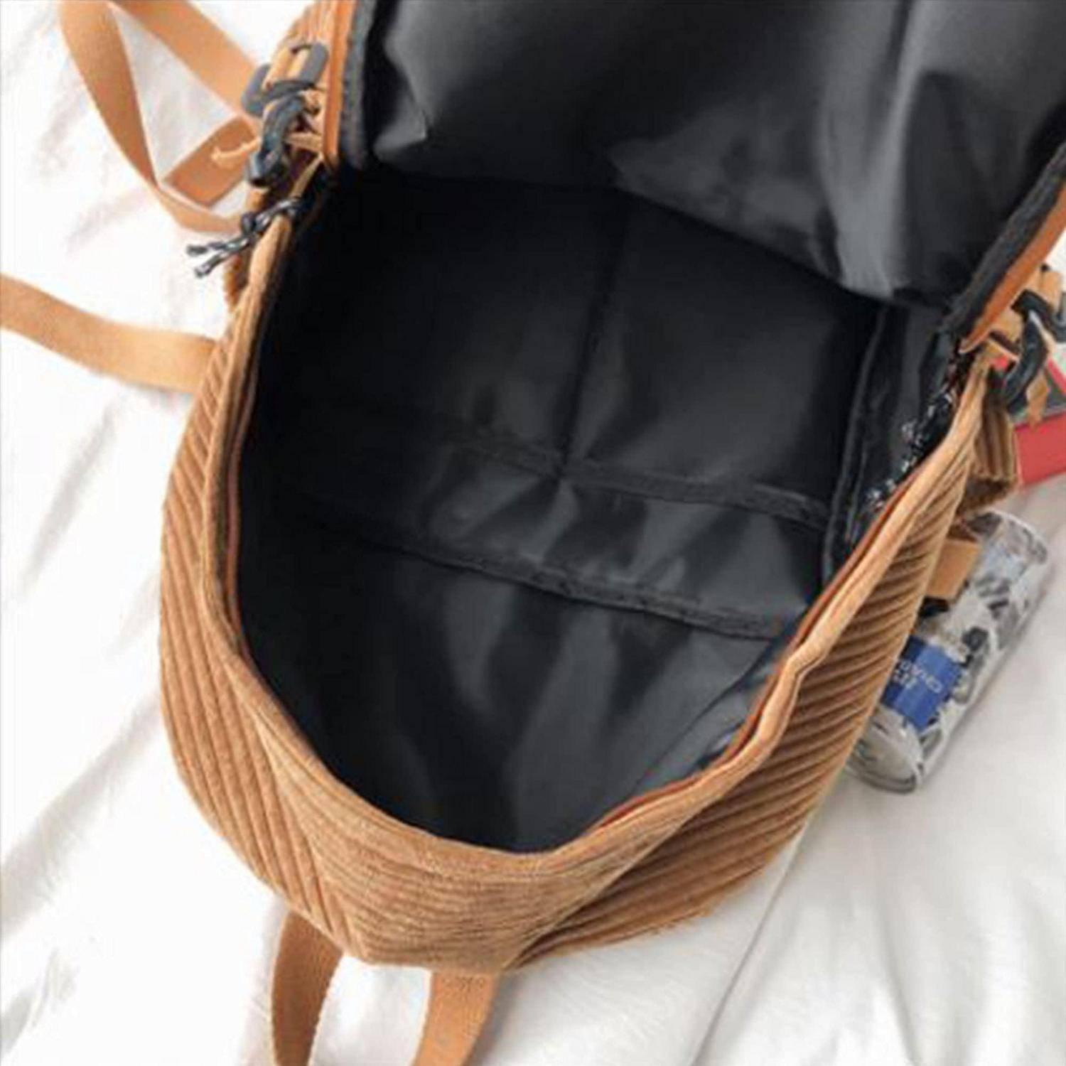 Offene beige Korduroy-Tasche mit schwarzem Futter und Reißverschluss, von oben auf einer weißen Oberfläche gezeigt.