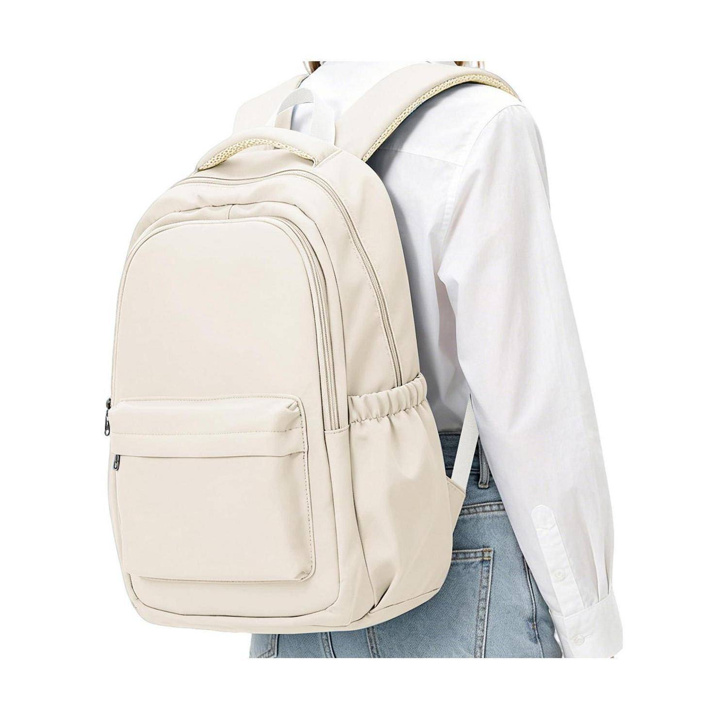 Person, die einen hellbeigen Rucksack mit einer vorderen Reißverschlusstasche und Seitentaschen über einem weißen Hemd und einer Jeans trägt.