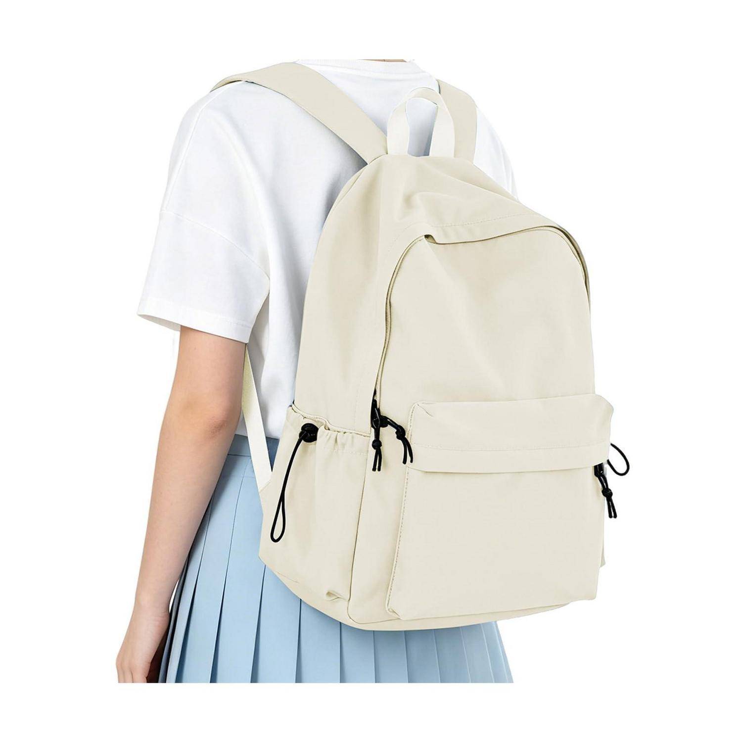 Cremefarbener Rucksack, getragen von einer Person in einem weißen Oberteil und einem blauen Rock, von hinten vor einem einfachen Hintergrund gezeigt.