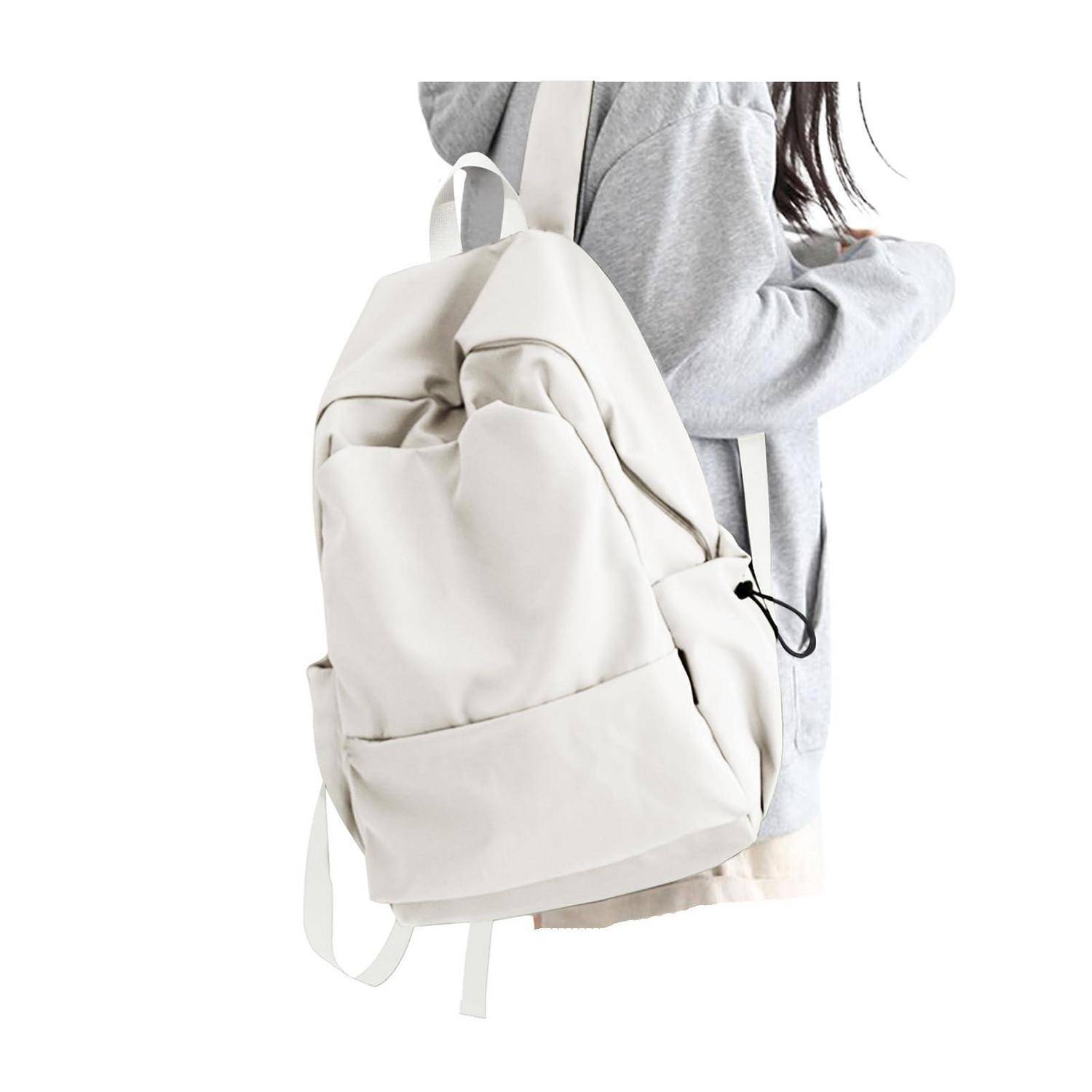 Person in einem grauen Hoodie mit einem großen weißen Rucksack auf einem einfachen weißen Hintergrund.
