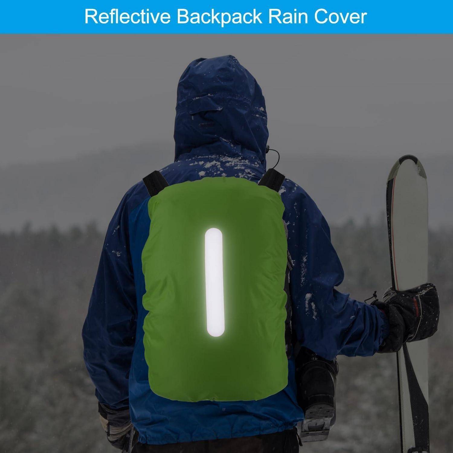 Person in blauer Winterkleidung, die eine leuchtend grüne reflektierende Rucksackregenschutzhülle mit weißem vertikalem Reflektorstreifen trägt, unter Schneefall.