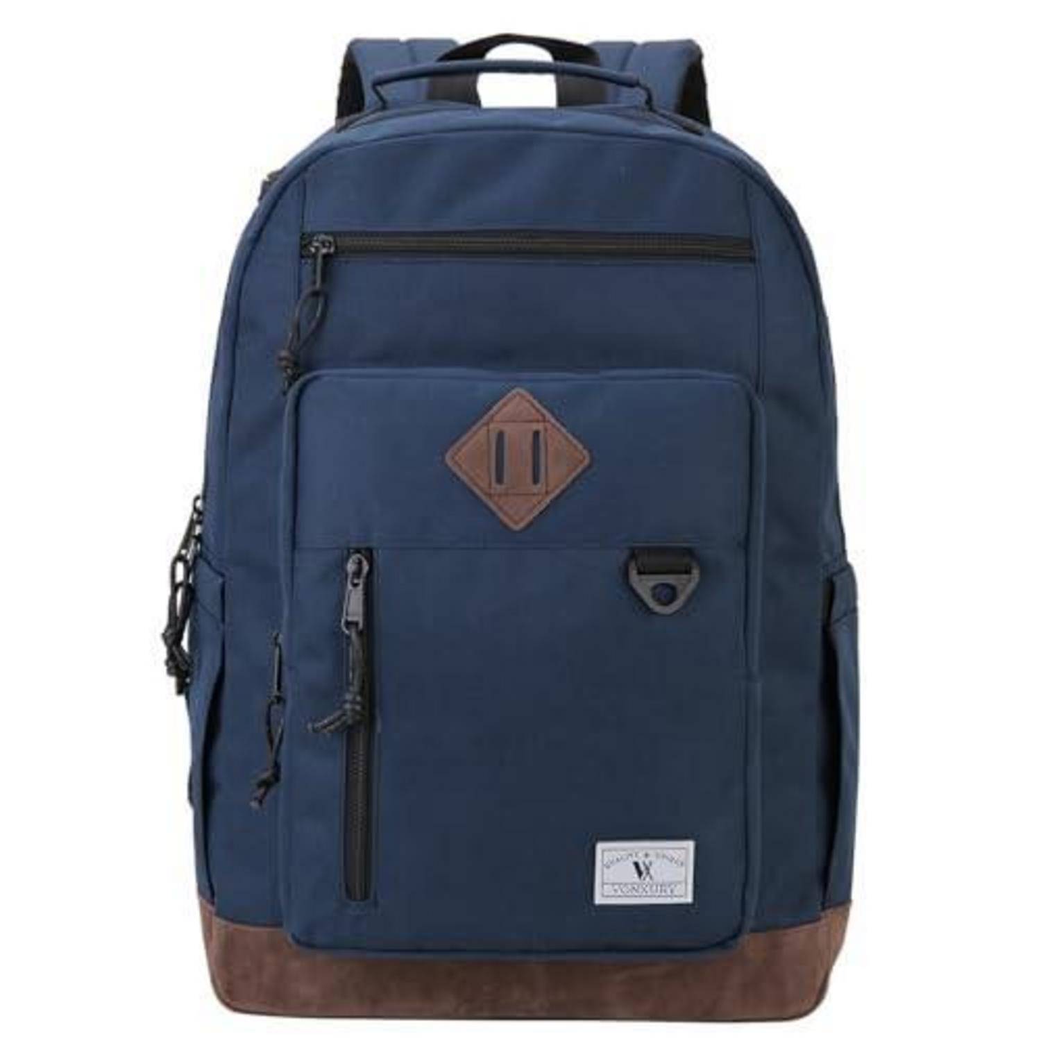 Dunkelblauer Rucksack mit brauner Basis, vorderen Reißverschlusstaschen und Leder-ähnlichem Logo-Patch, shown auf einem einfachen weißen Hintergrund.