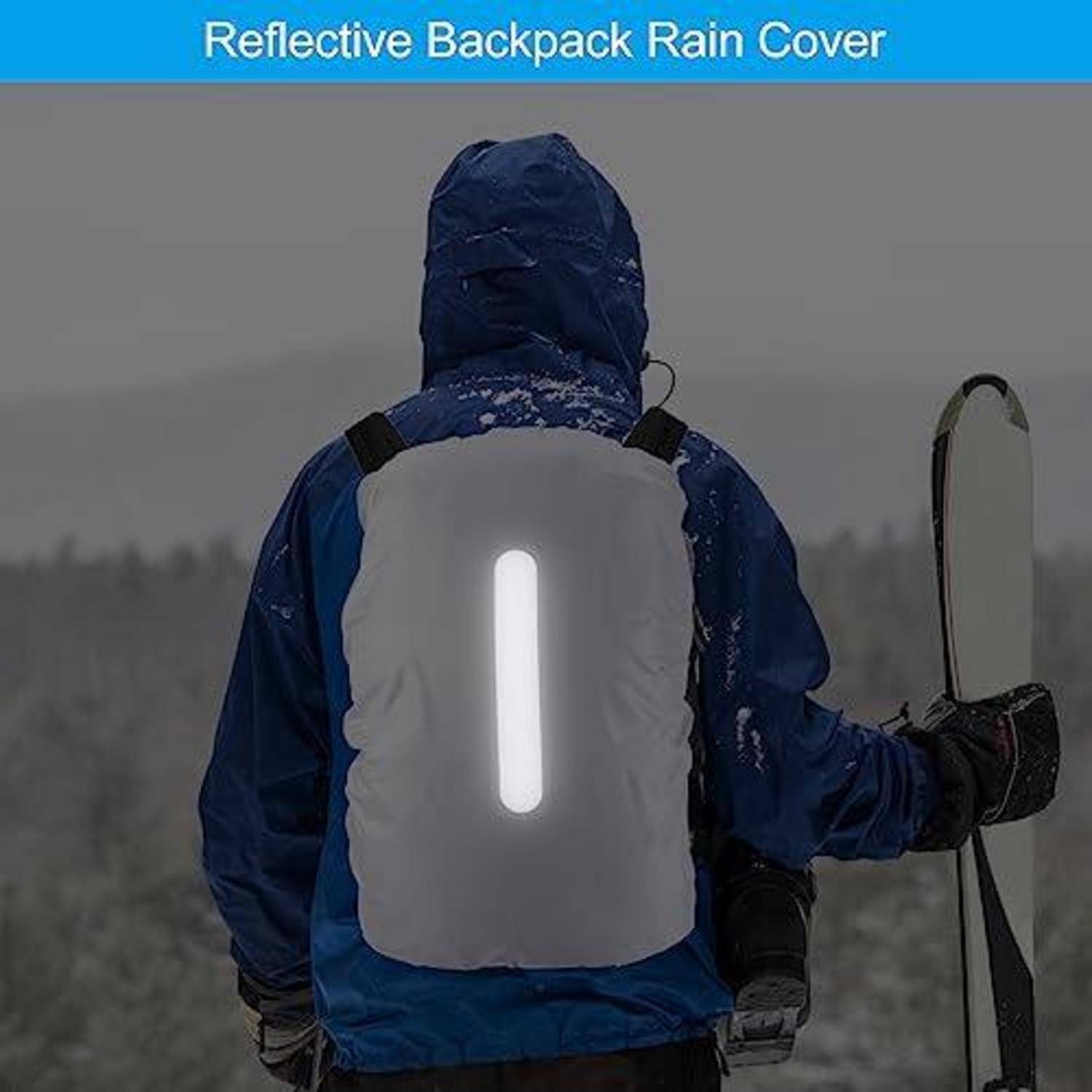Person in blauer Außenjacke, die eine reflektierende Rucksackregenabdeckung mit einem vertikalen hellen Streifen trägt, hält ein Snowboard bei schneeigem Wetter.