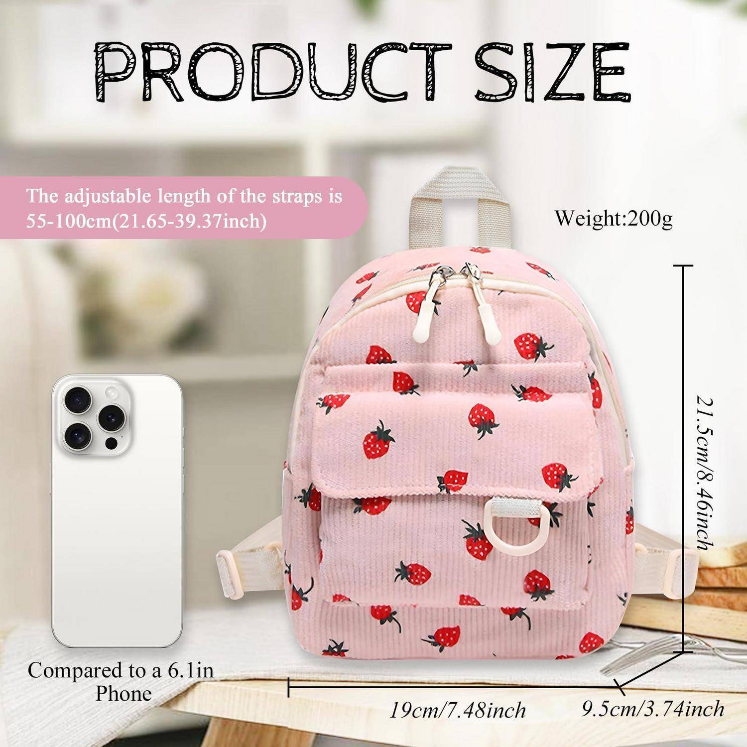 Rosa Mini-Rucksack mit Erdbeerdruck, abgebildet mit einem Telefon für einen Größenvergleich. Der Produktgrößentext gibt verstellbare Riemen von 55-100 cm, Gewicht 200 g, Abmessungen 21,5 x 19 x 9,5 cm an.