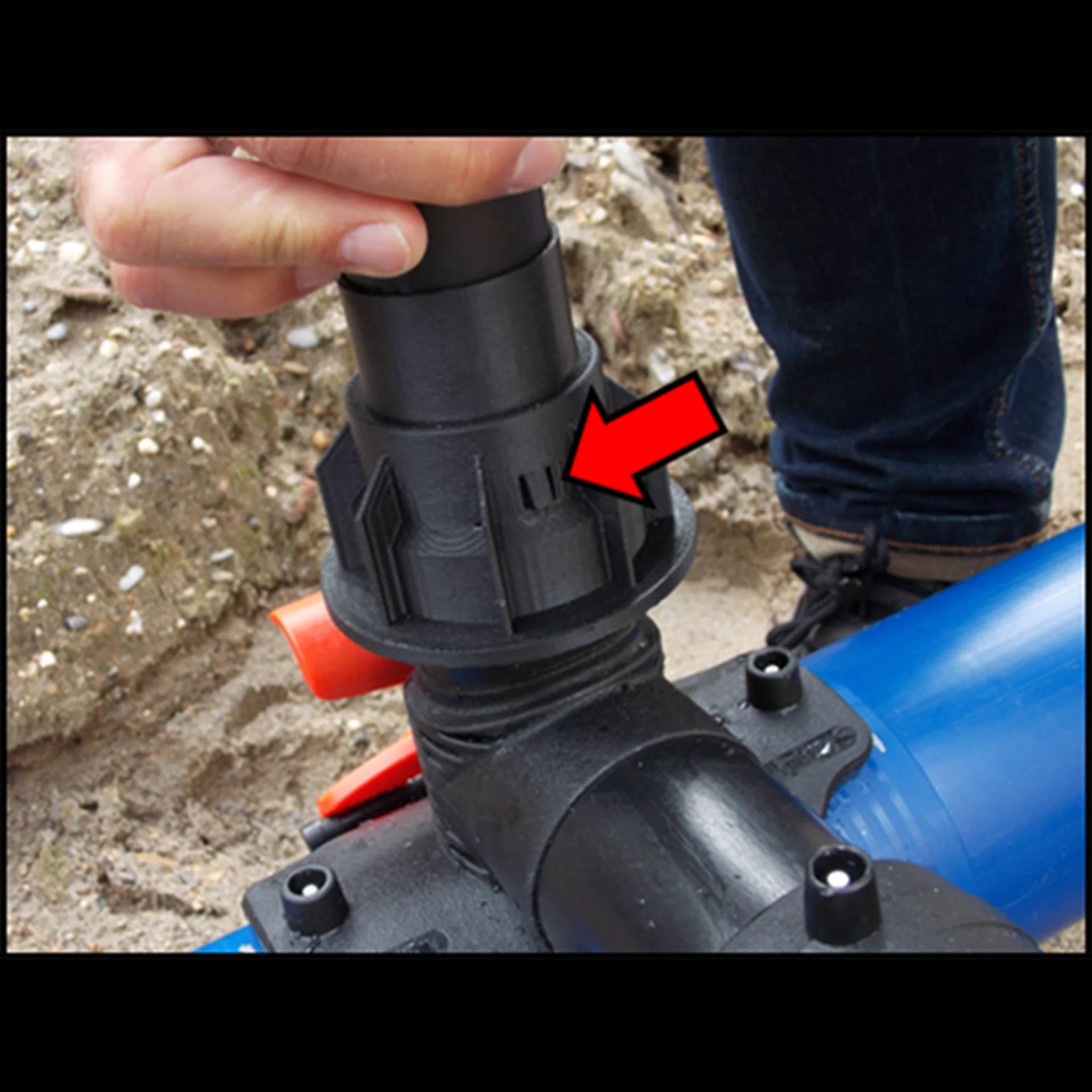 Nahaufnahme einer Hand, die eine schwarze Rohrverbindung auf einem blauen Rohr anzieht, mit einem roten Pfeil, der den Verriegelungs- oder Ausrichtungsreiter hervorhebt.