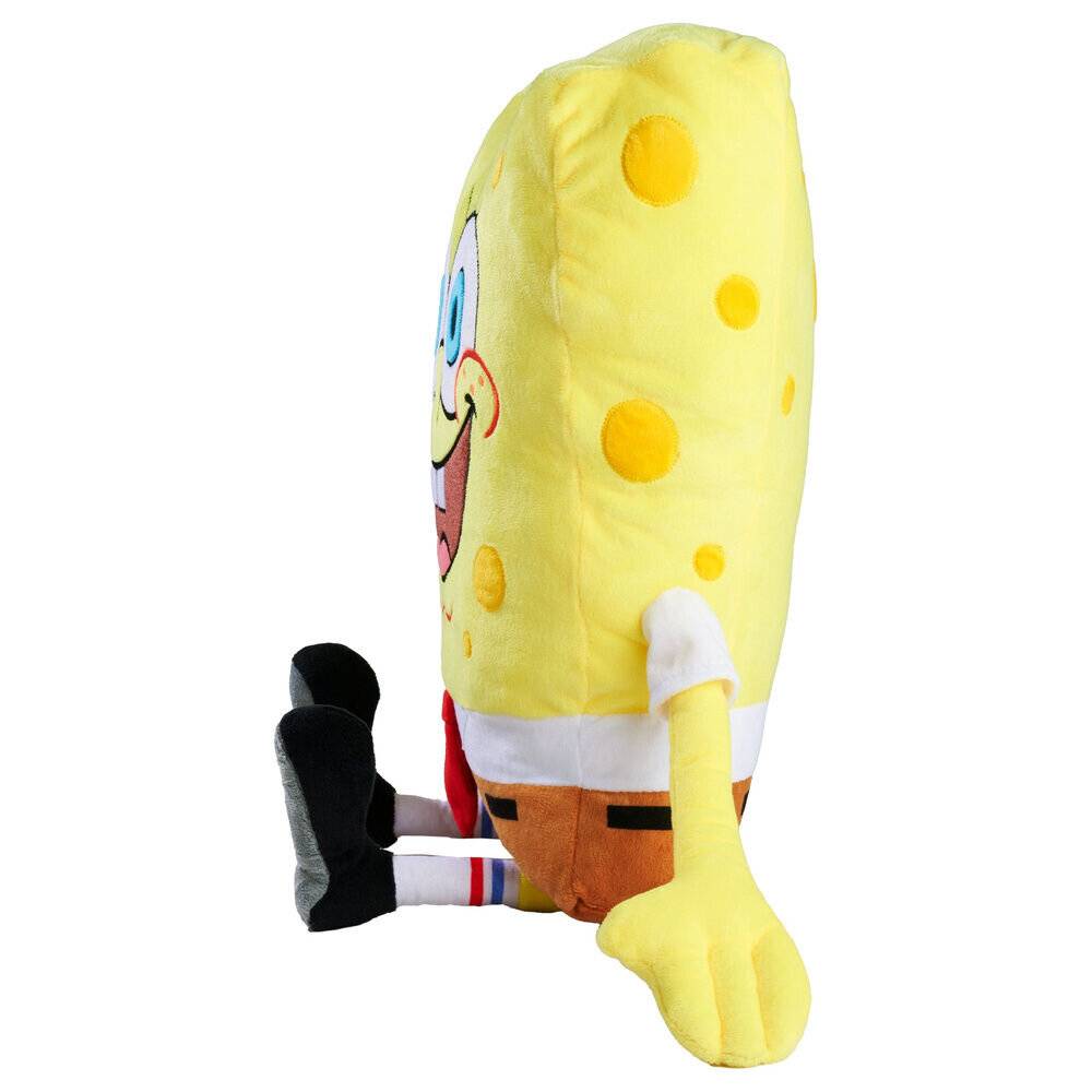 Seitenansicht eines SpongeBob Schwammkopf-Plüschtiers, das mit ausgestreckten Beinen auf weißem Hintergrund sitzt.