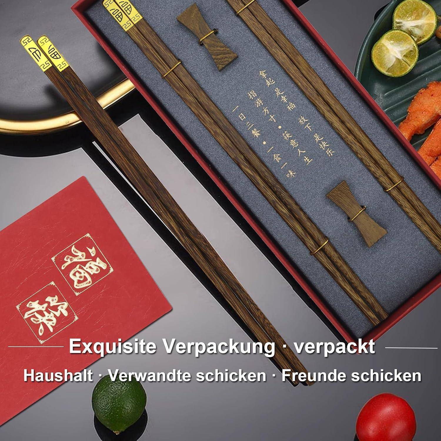 Luxusgeschenkbox mit Essstäbchen und einem roten Umschlag, beschriftet auf Chinesisch, neben Tellern mit Speisen und Obst.