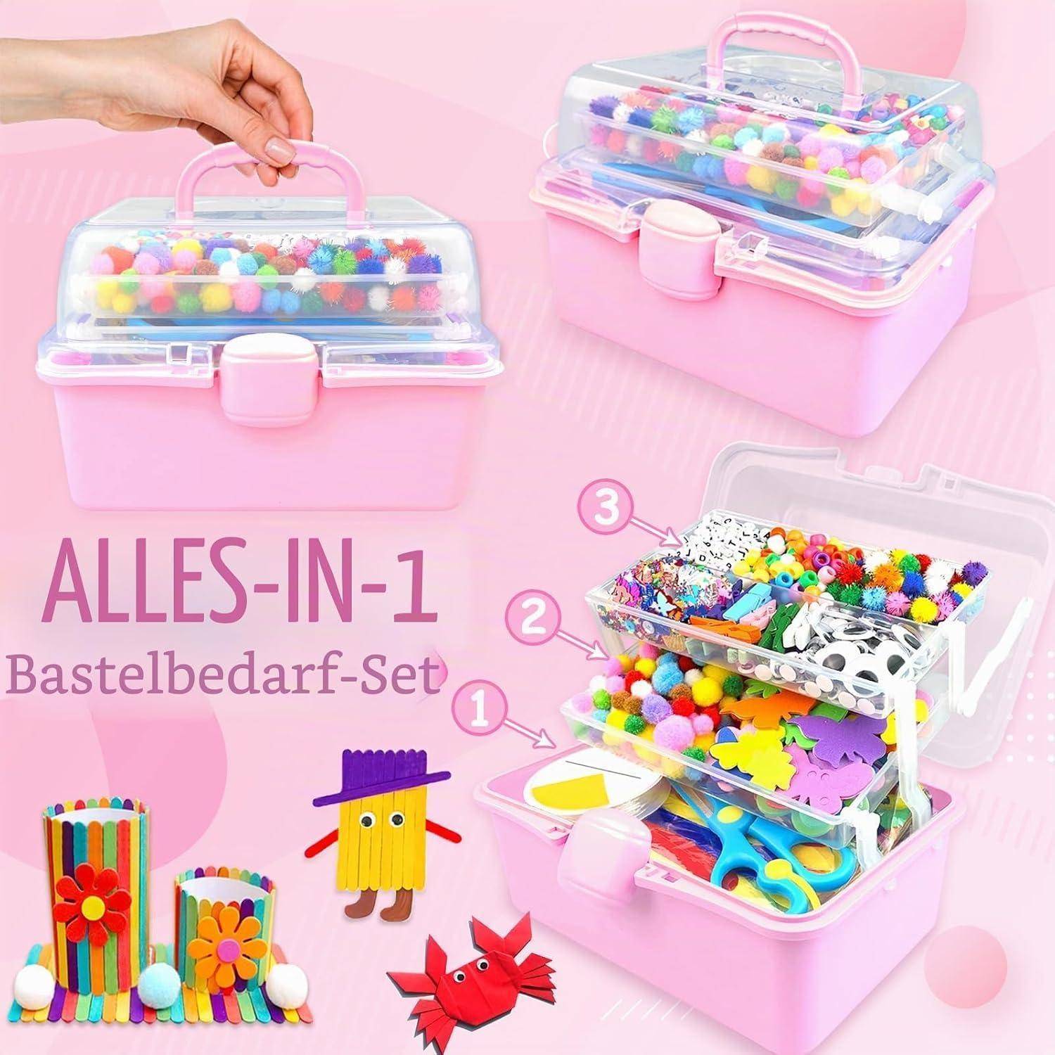 Rosa All-in-1 Bastelbedarf-Aufbewahrungset mit Boxen mit klarem Deckel, unterteilt nach nummerierten Ebenen und gefüllt mit Pompons, Perlen, Aufklebern und Scheren; deutscher Text liest sich als 'ALLES-IN-1 Bastelbedarf-Set'.