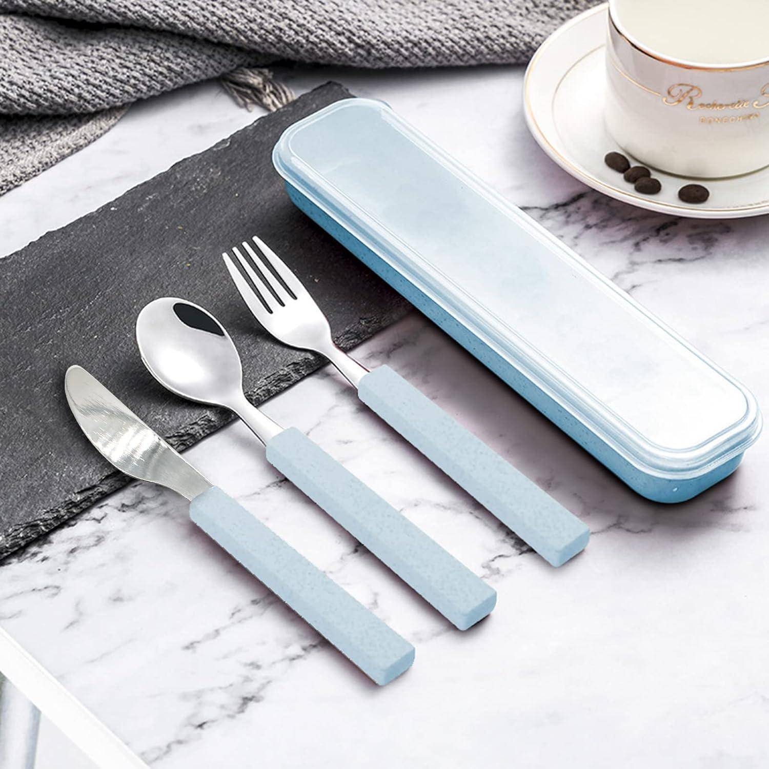 Hellblau gestieltes Messer, Löffel und Gabel neben einem passenden rechteckigen Behälter auf einer Marmoroberfläche mit einer Tasse und Untertasse.