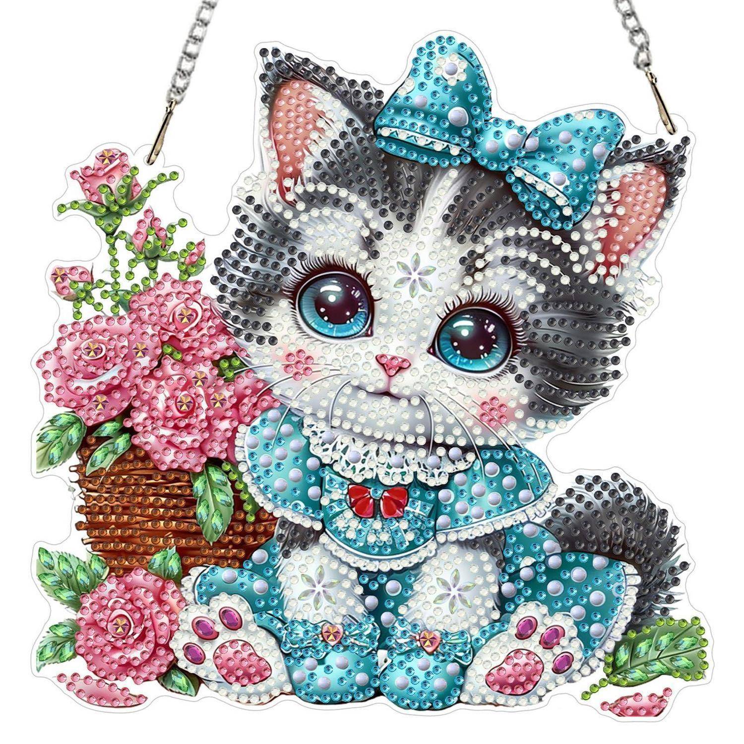 Glitzerndes Kätzchen-Anhänger mit blauer Schleife, das neben rosa Blumen in einem Korb sitzt.