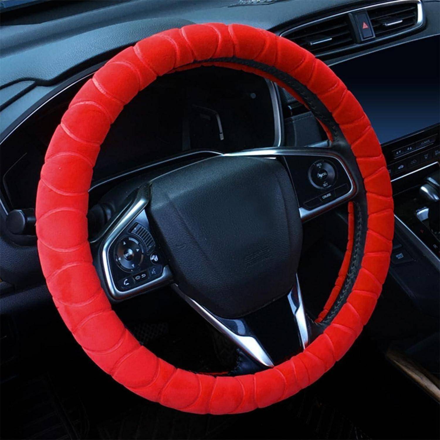 Autoinnenraum mit einer roten Lenkradabdeckung auf einem schwarzen Lenkrad, aus der Perspektive des Fahrersitzes.