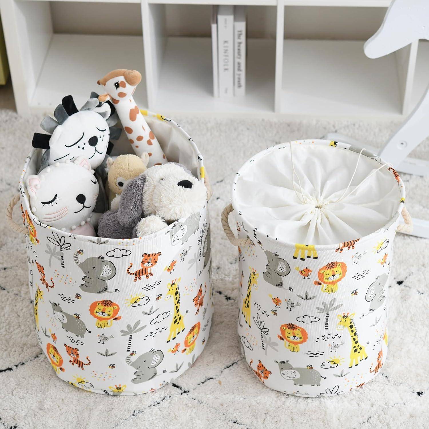Zwei weiße Stofflagerkisten mit bunten Tiermotiven; die linke Kiste ist mit Kuscheltieren gefüllt, die rechte Kiste ist geschlossen und leer.